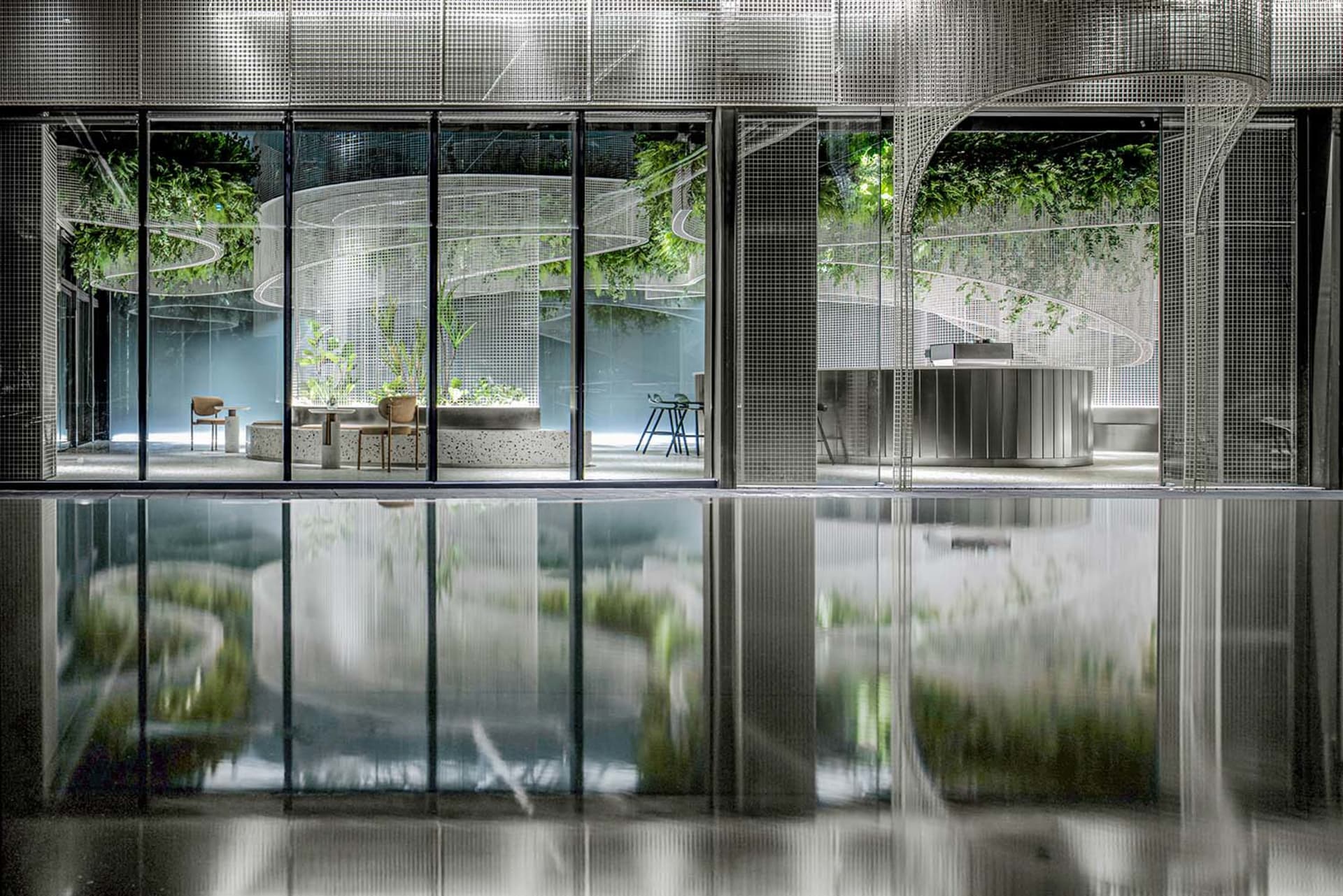 Indoor pool area with glass doors, empty pool, and reflective surface due to nearby windows
