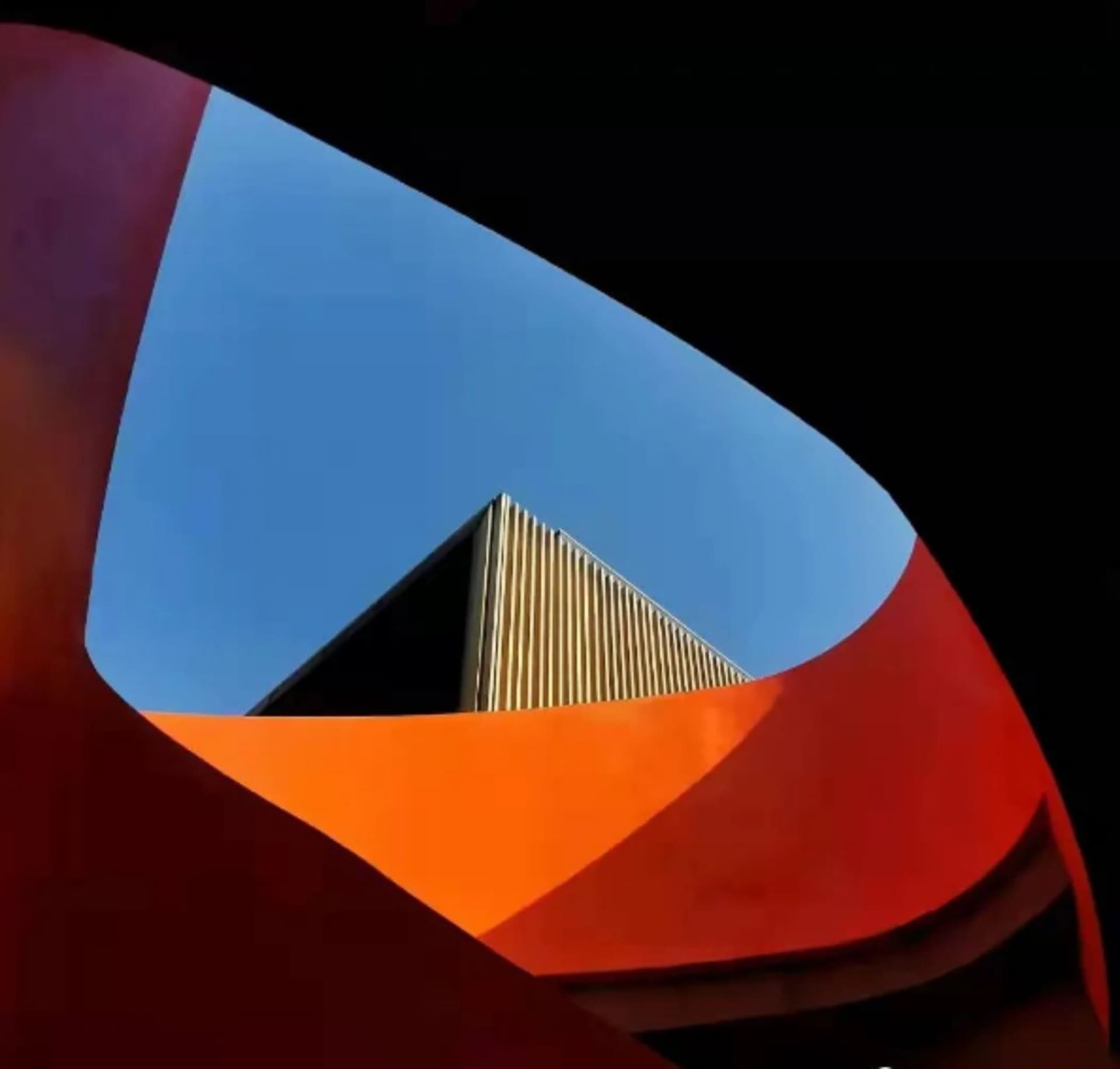 A bright and intriguing spiral staircase made of concrete, set against a well-lit background