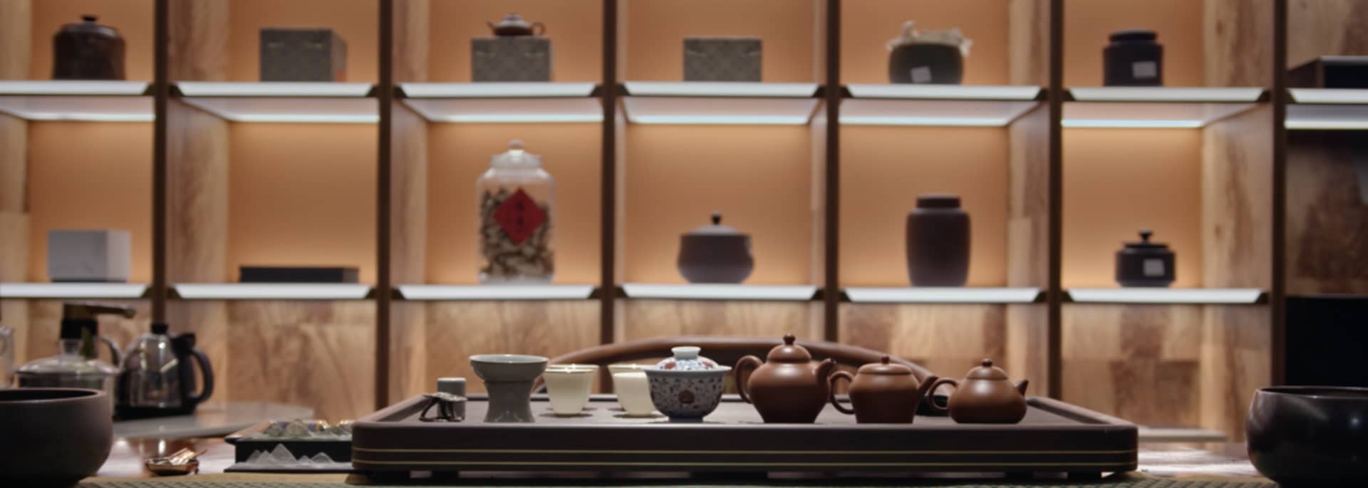 木桌上以誘人陳設擺放各式茶壺與茶杯