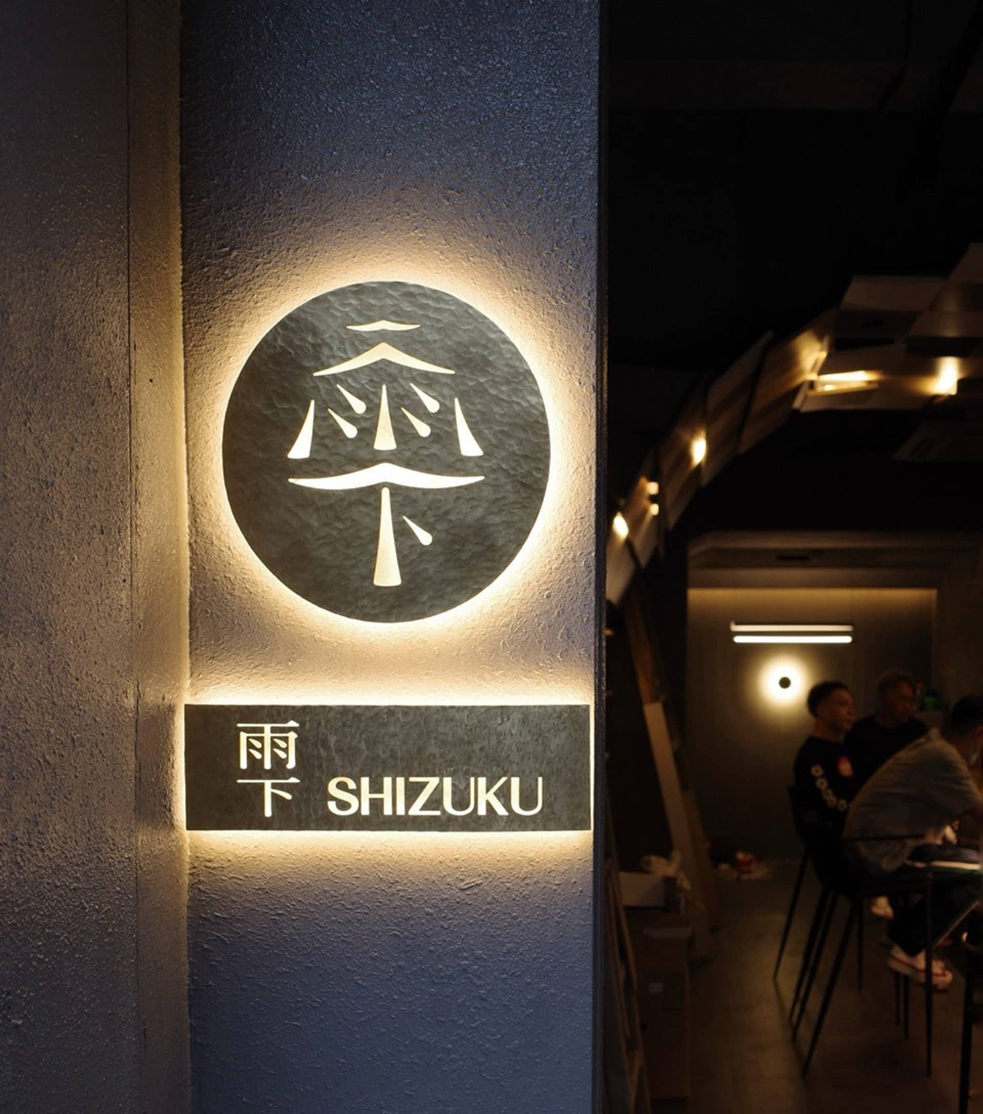 Casual dining area with wooden furniture, people enjoying meals and conversations, and a warm atmosphere