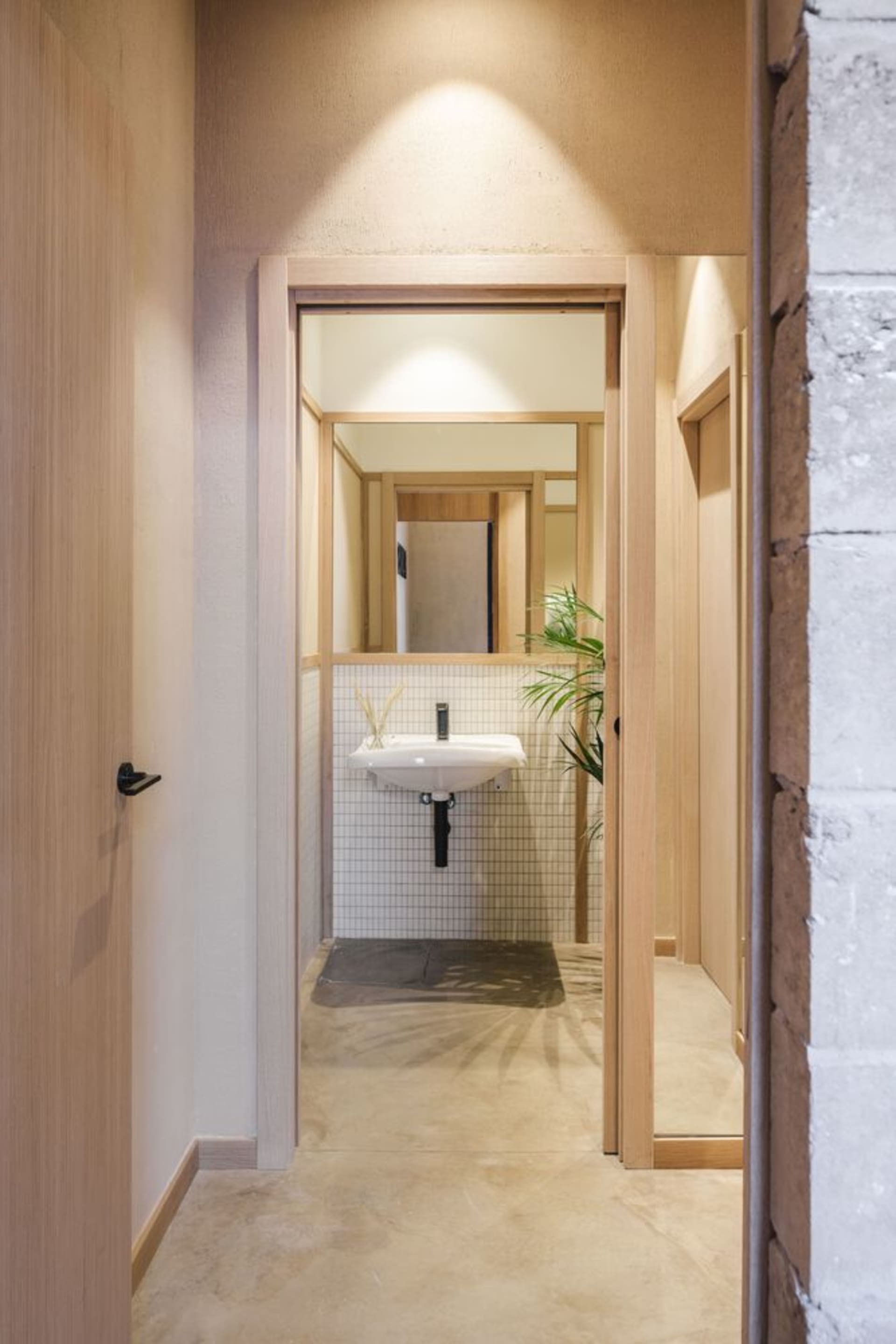 Bathroom with two sinks, wooden walls, and a tiled floor, lit by natural light