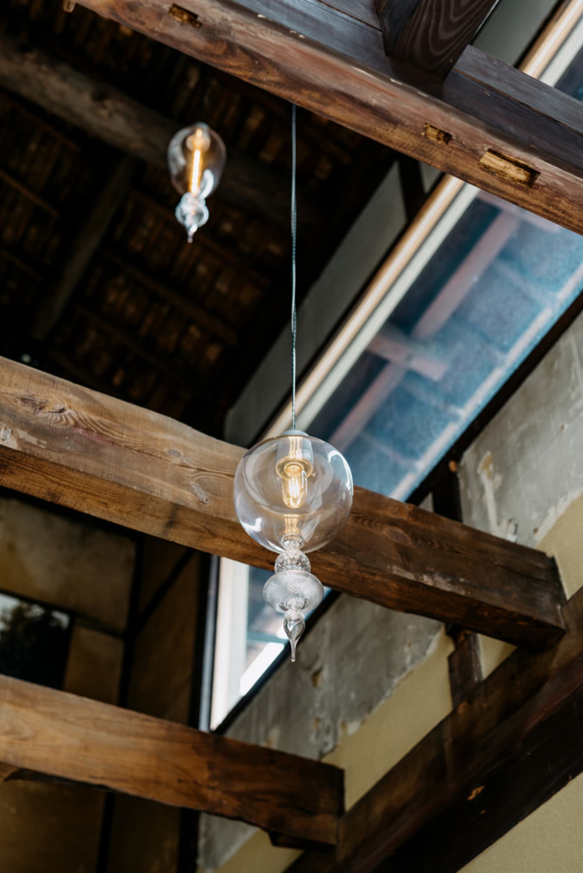 A rustic cafe interior with wooden beams and a glass chandelier, featuring a cozy atmosphere and aged building appearance