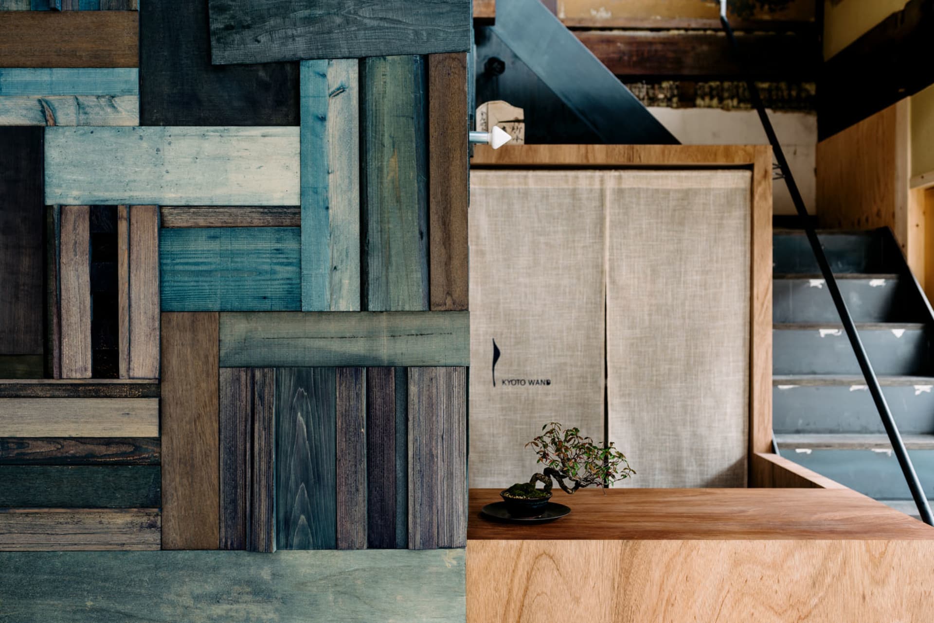 Warm and inviting living area with wooden walls, floors, and furniture, featuring a potted plant and natural textures