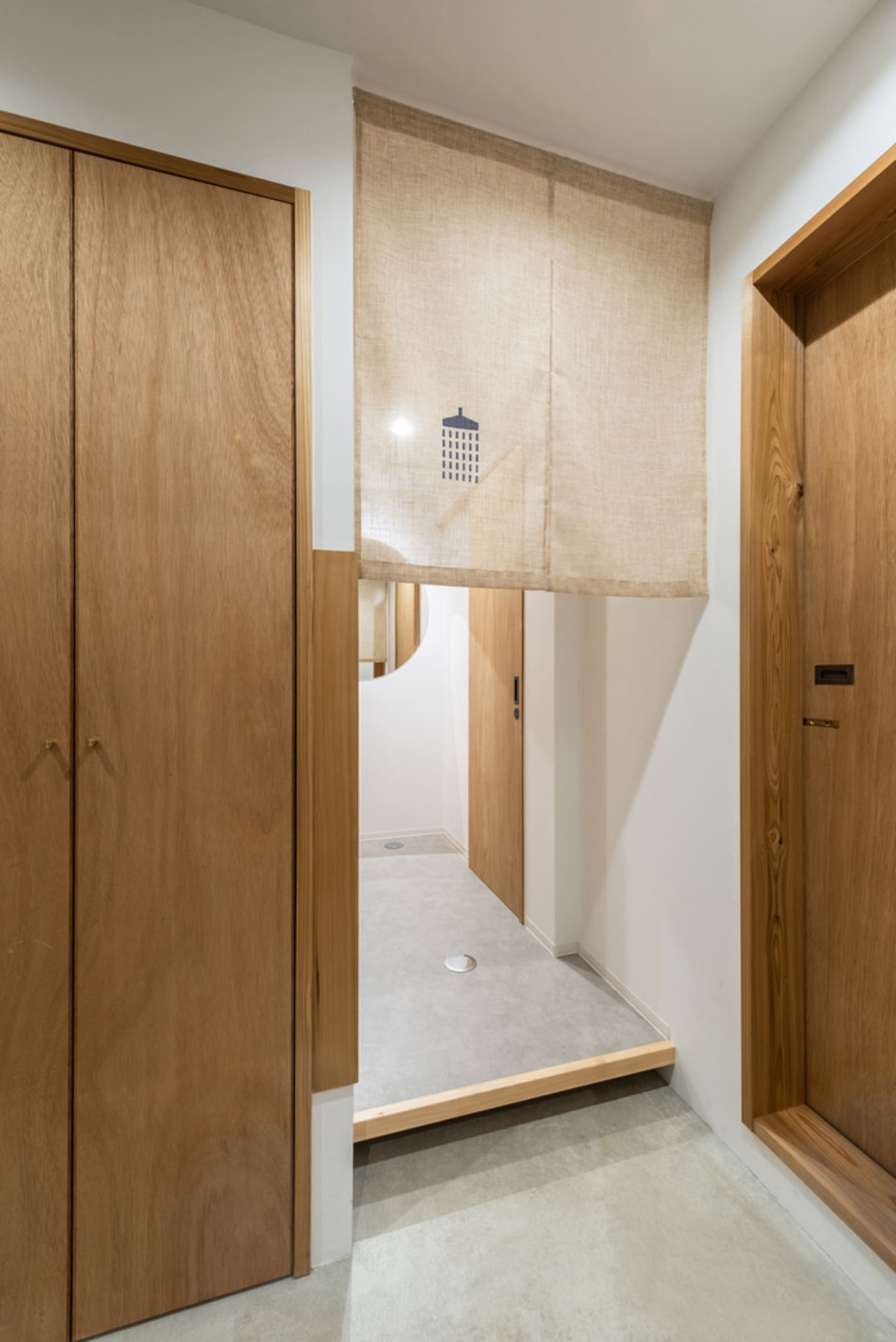 Bathroom with wooden cabinets, brown finish, two doors, and a shower curtain for privacy