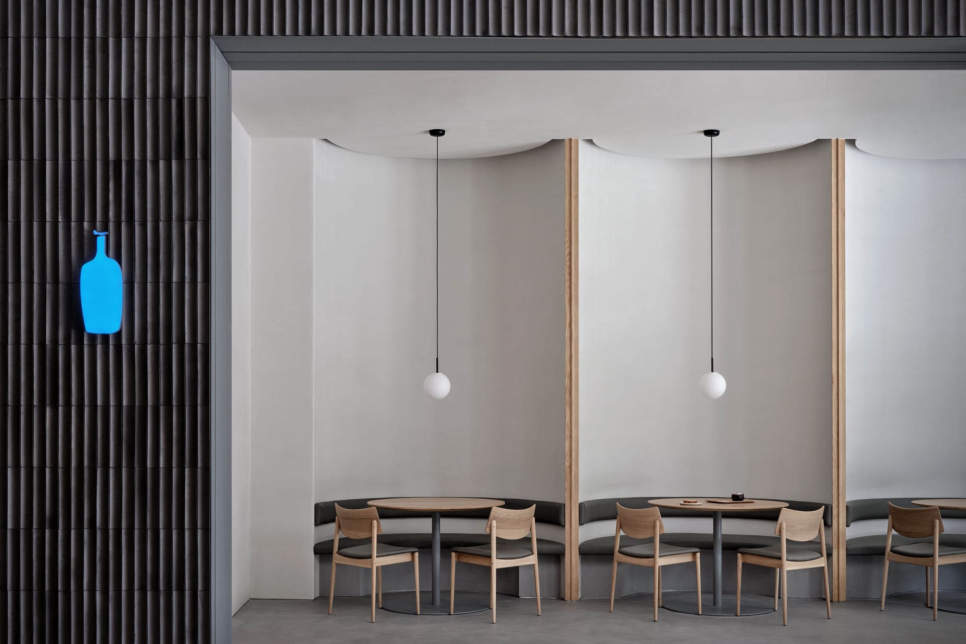 A spacious restaurant dining area with a long wooden table surrounded by multiple chairs, set in a clean and inviting atmosphere