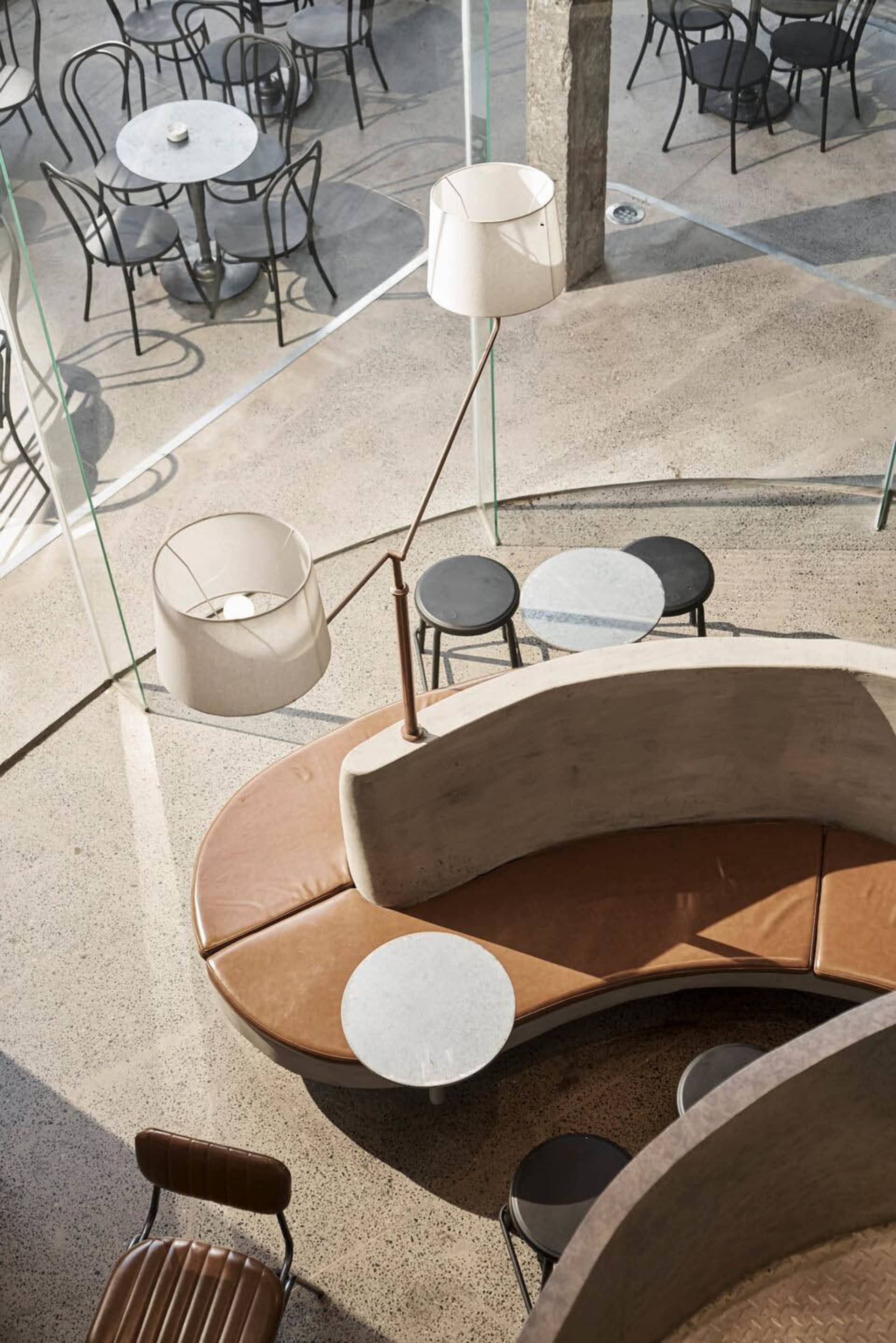 Inviting cafe with a circular seating area featuring multiple tables and chairs, creating a comfortable atmosphere for socializing and dining