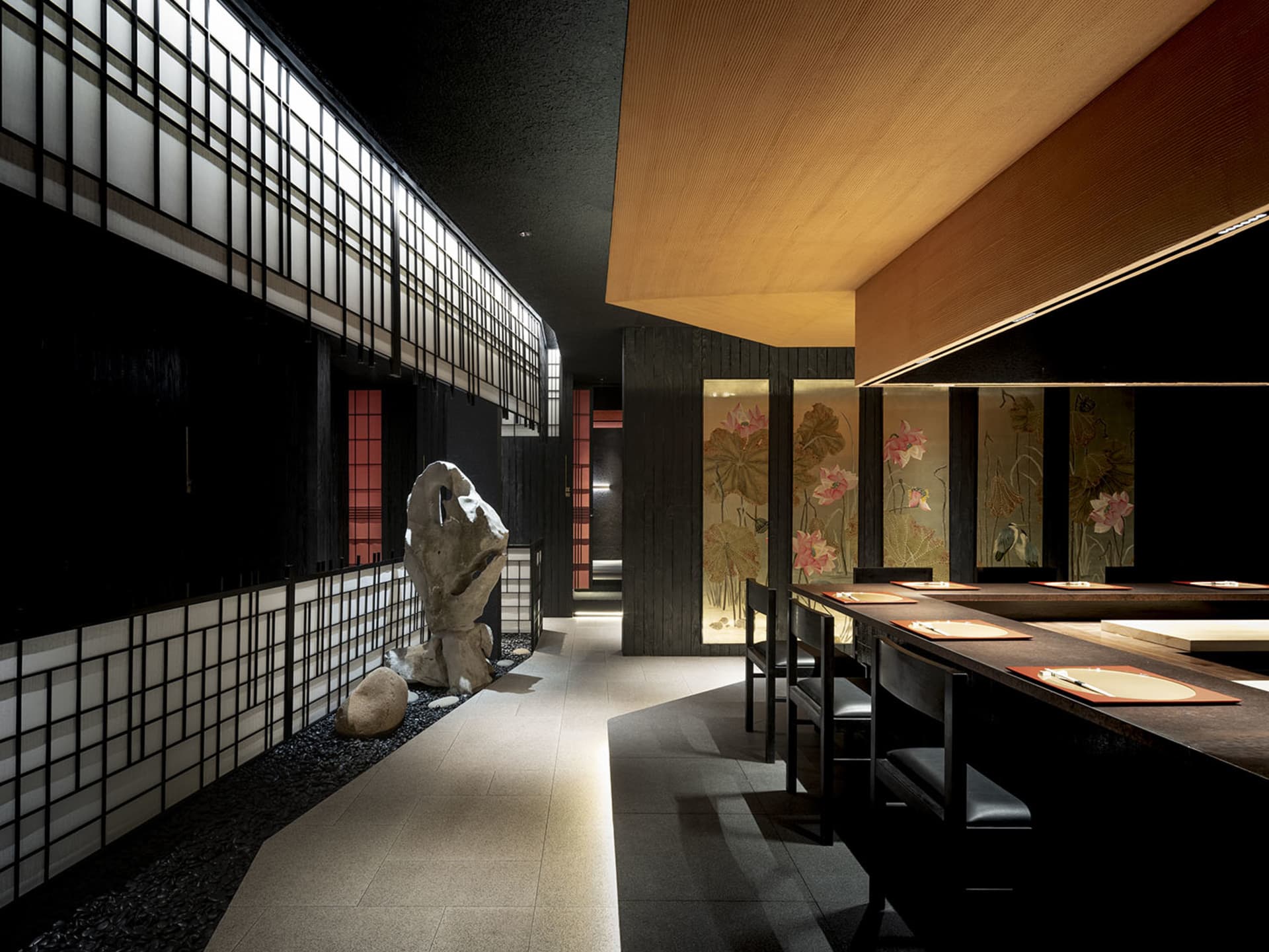 A modern Asian restaurant with tile flooring, tables, chairs, and potted plants, complemented by artwork on the walls