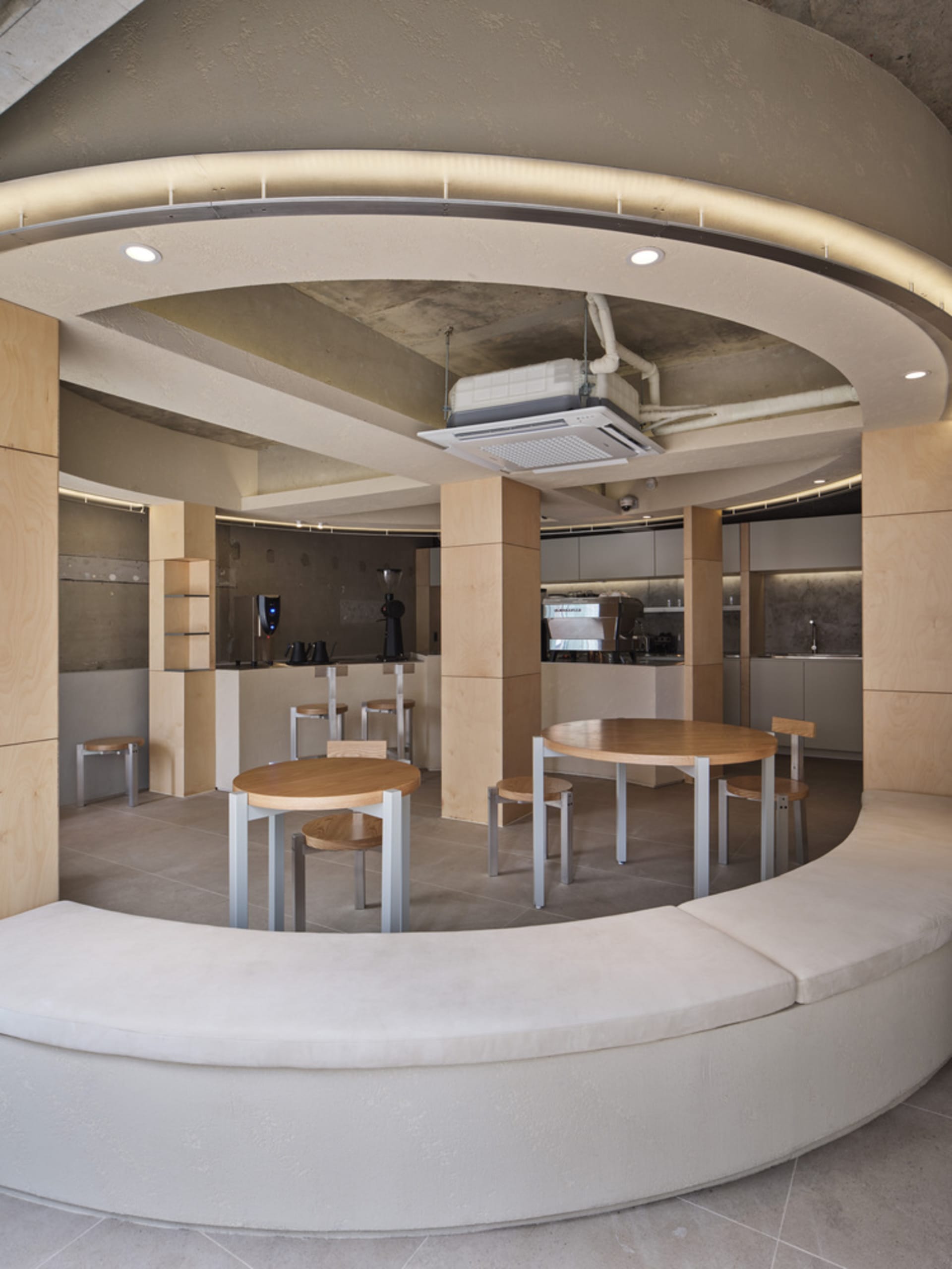 A cozy restaurant interior with wooden tables and chairs arranged in a circular fashion, creating an inviting atmosphere for patrons to enjoy their meals or conversations