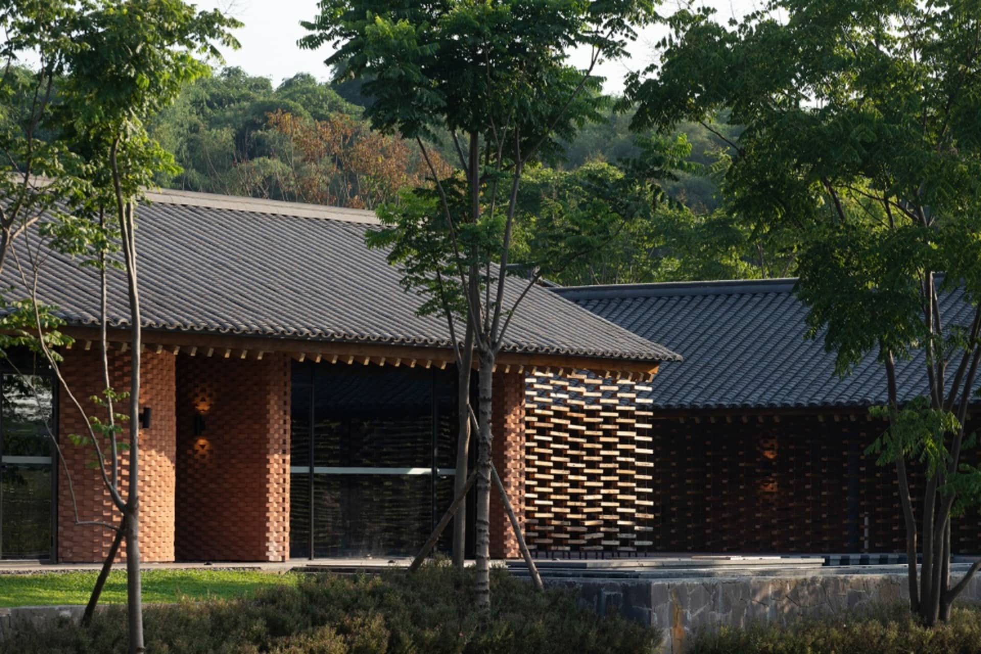 Asian-style building with wooden walls, tiled roof, and multiple windows, set in a serene and inviting atmosphere