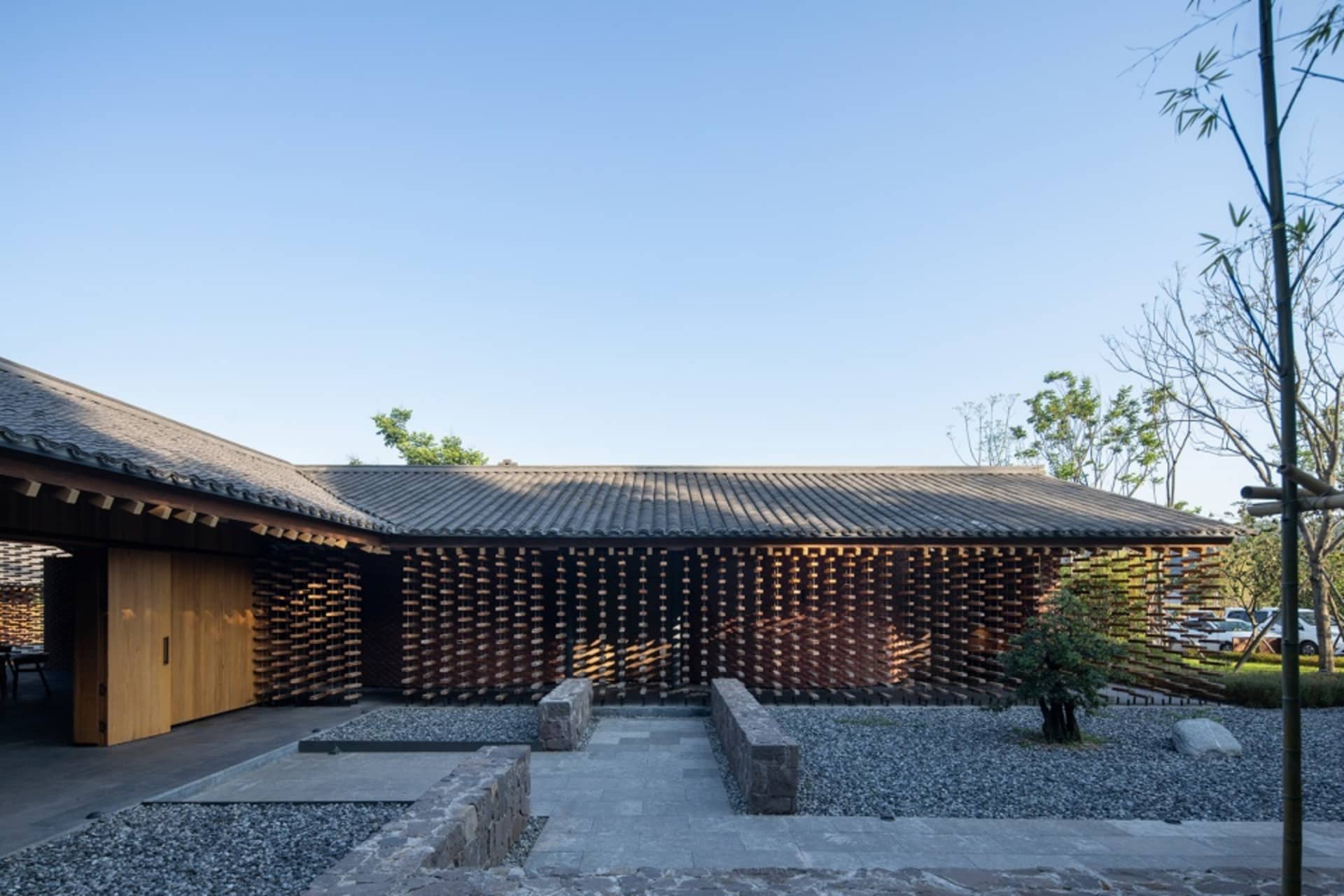 Asian-style house with a wooden exterior, featuring a large roof, a mix of open spaces and enclosed rooms, and a blend of traditional and modern elements