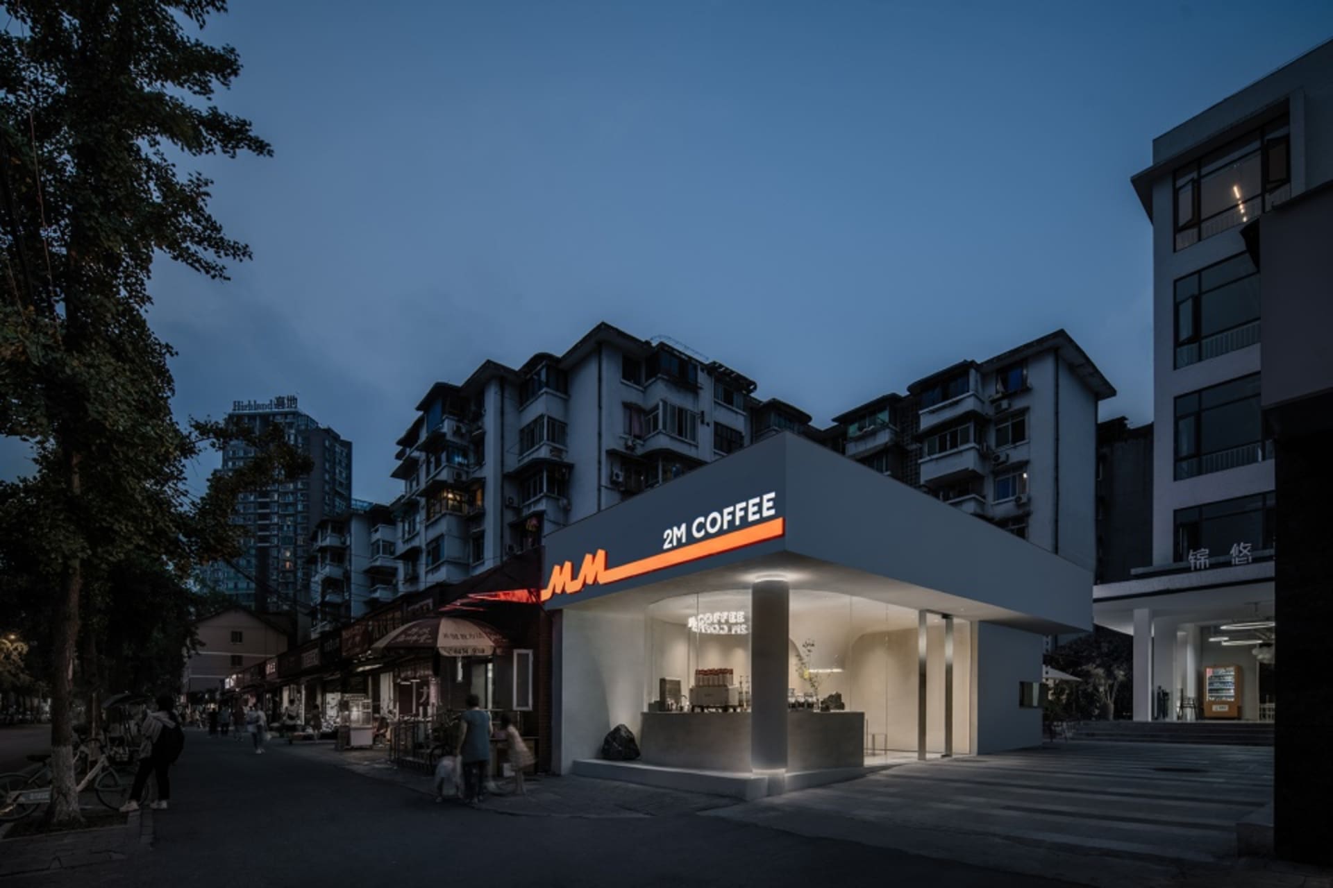 夜晚熱鬧的咖啡店內有多位顧客，周圍環繞大片窗戶與活潑氛圍