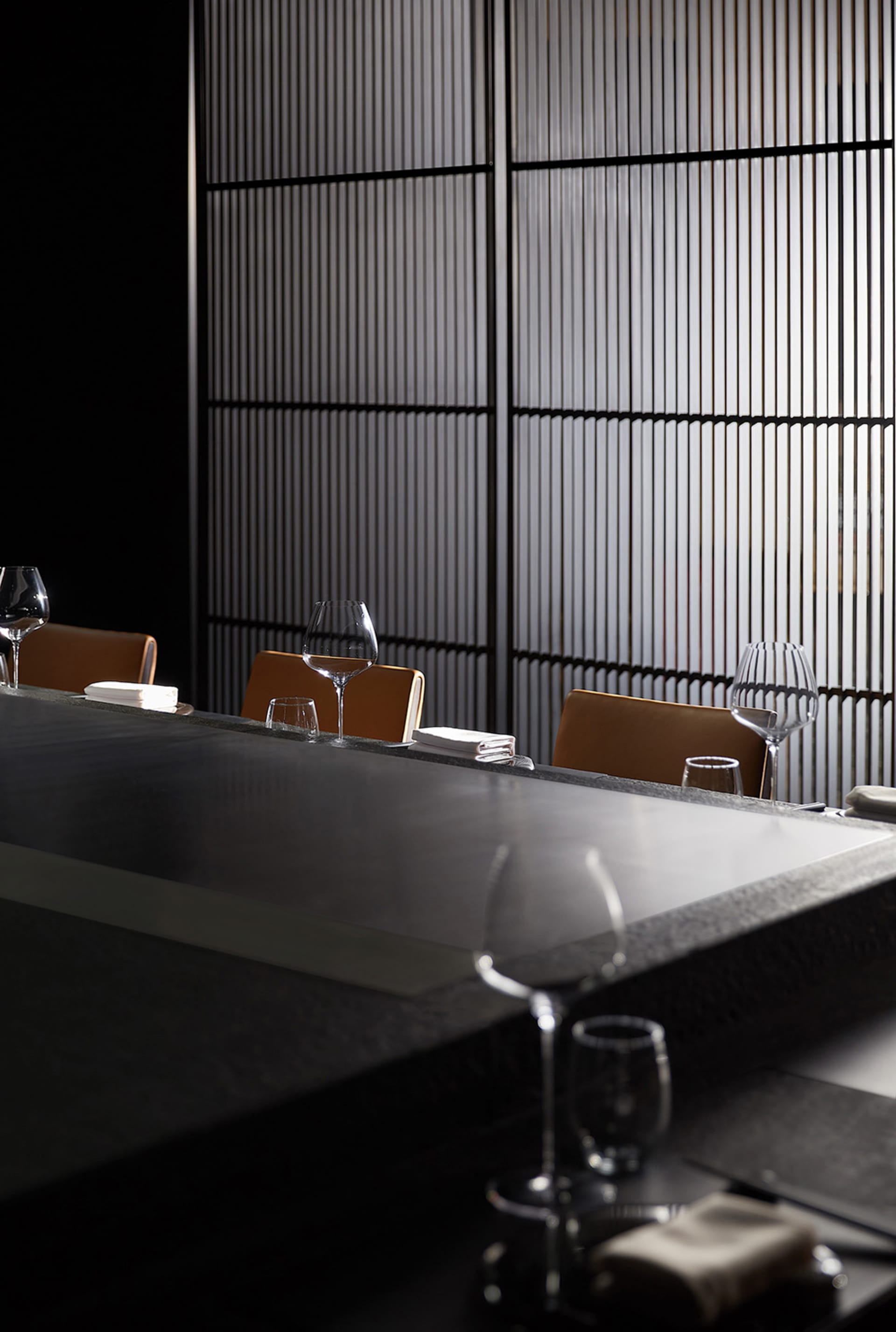 Formal dining space with a long wooden table and chairs, wine glasses, and a sophisticated atmosphere