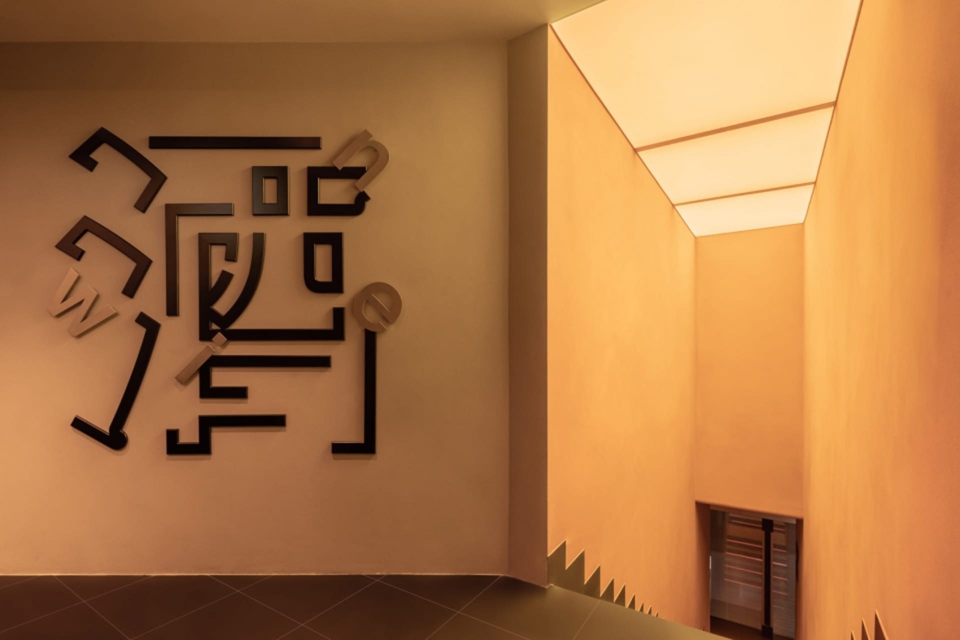 A dimly lit room with a unique puzzle wall design, no furniture or people in sight