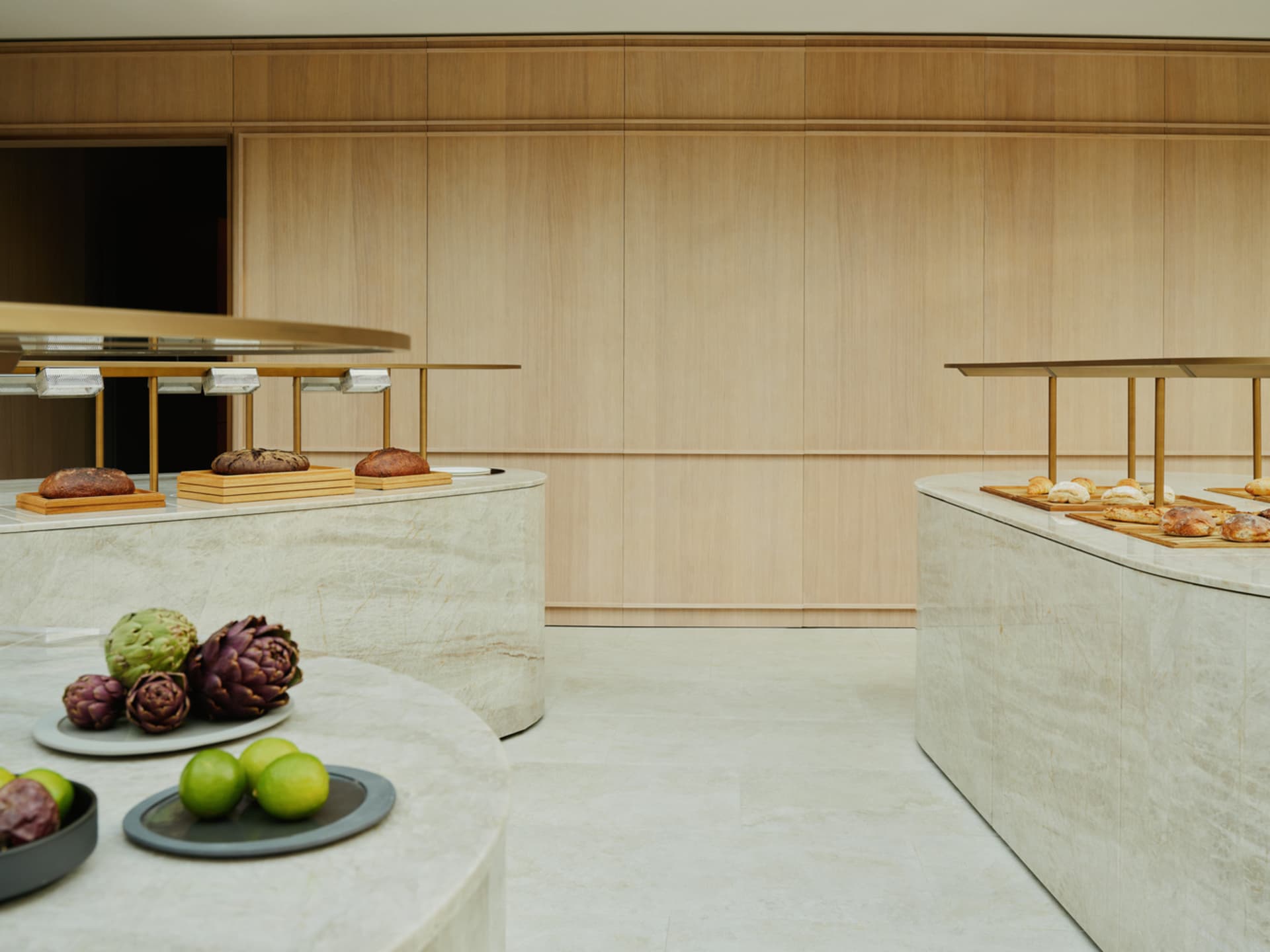 Empty restaurant kitchen with wooden walls and floors, featuring dining tables with various food items and a clean, organized atmosphere