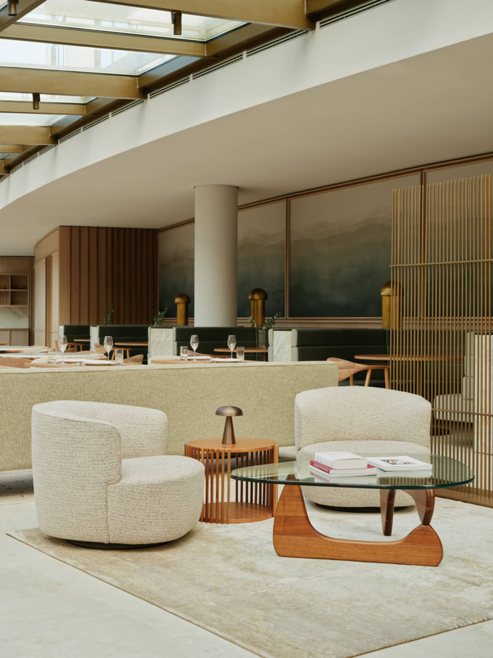 A modern hotel lobby with a warm atmosphere, featuring wood and glass surfaces, comfortable seating areas, and strategic lighting