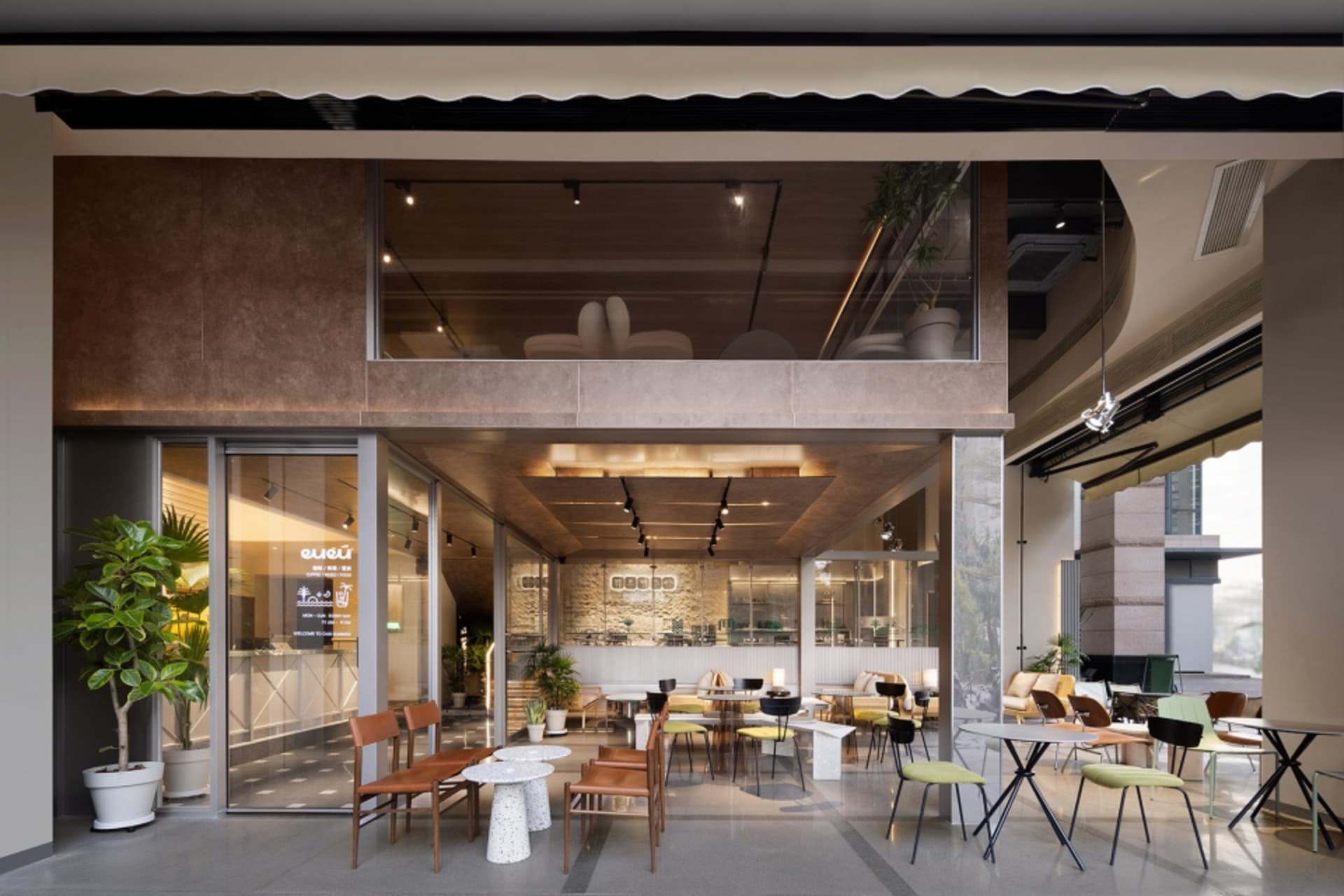 A well-lit restaurant interior with tables, chairs, potted plants, and decorative elements, creating a warm and inviting atmosphere
