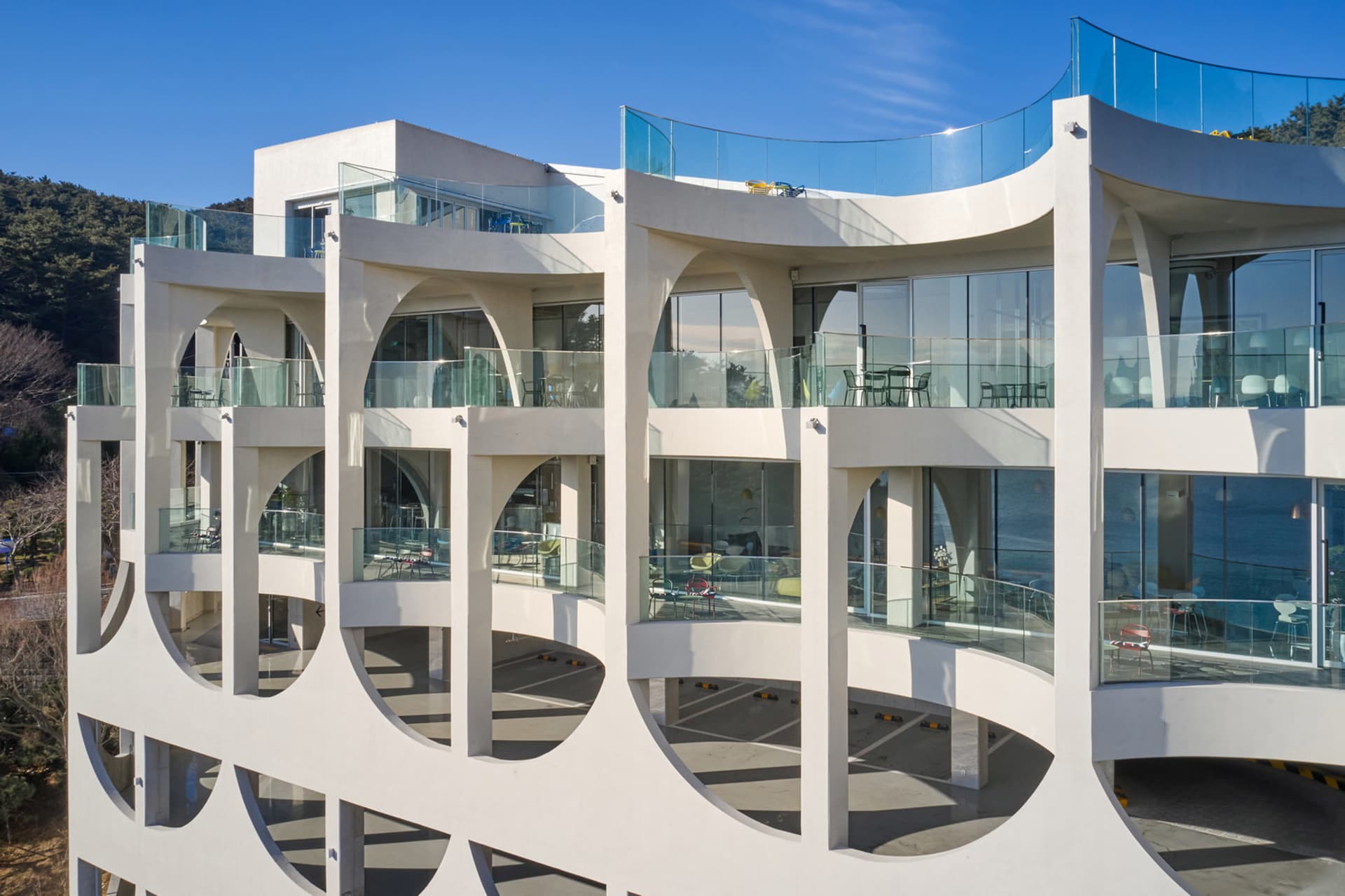 Modern building with white walls, glass windows, and a balcony seating area