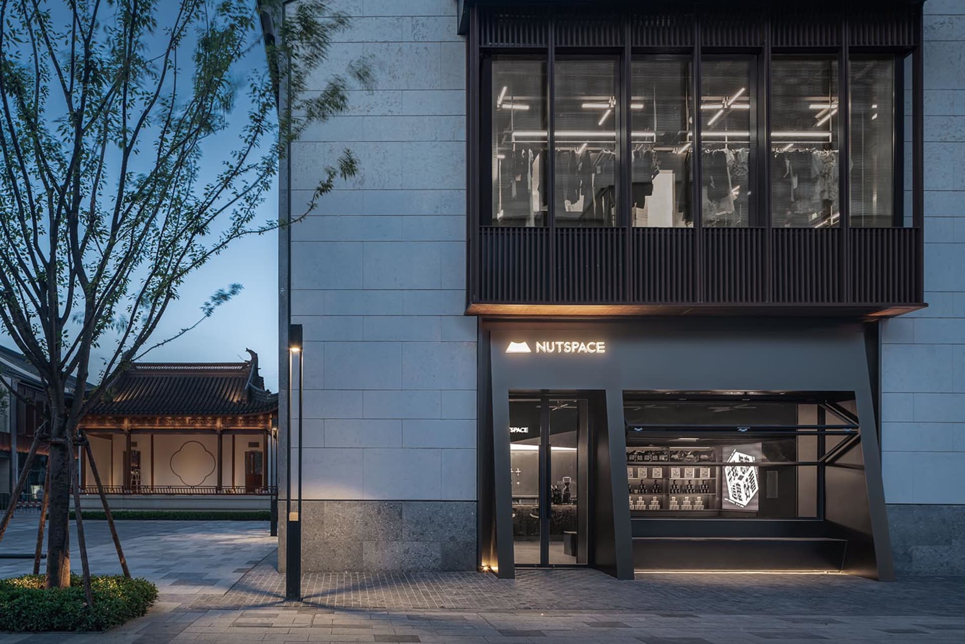 A modern building with a storefront and two large windows, set against a bustling city backdrop