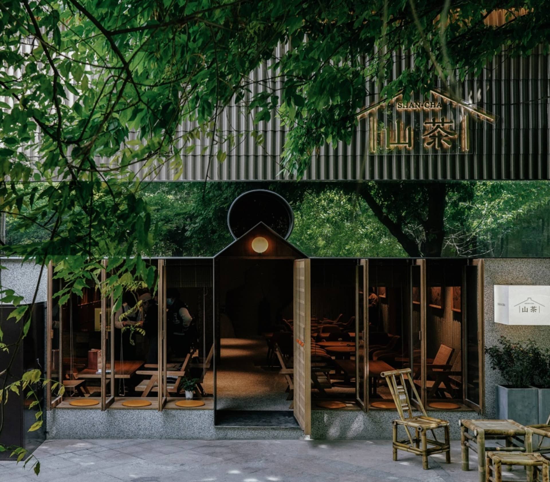 現代亞洲餐廳擁有寬敞用餐區、椅子與長椅，周圍環繞自然元素並具備充足採光室內設計