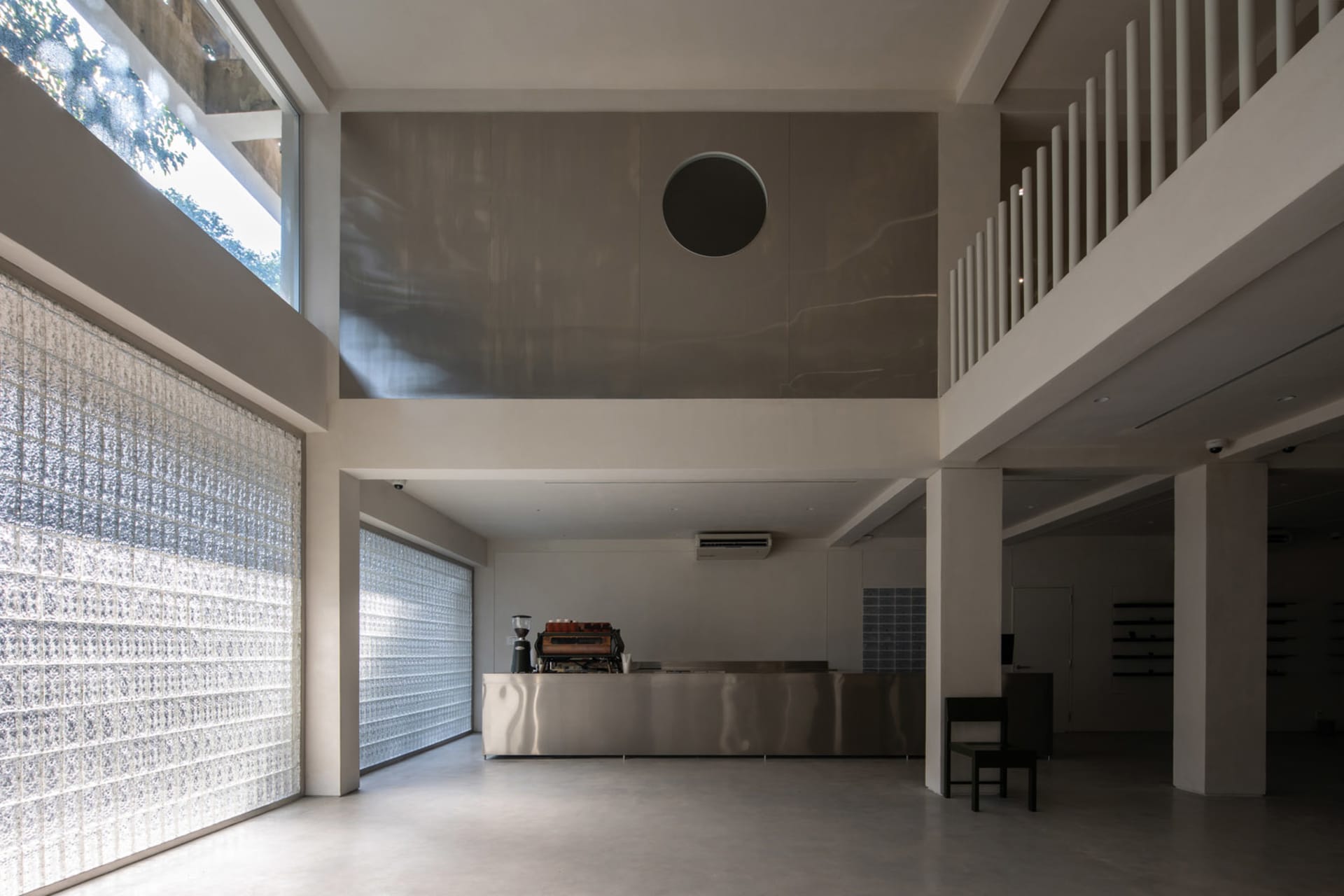 Open modern living space with a metal bar, sleek countertop, and natural light from a large window