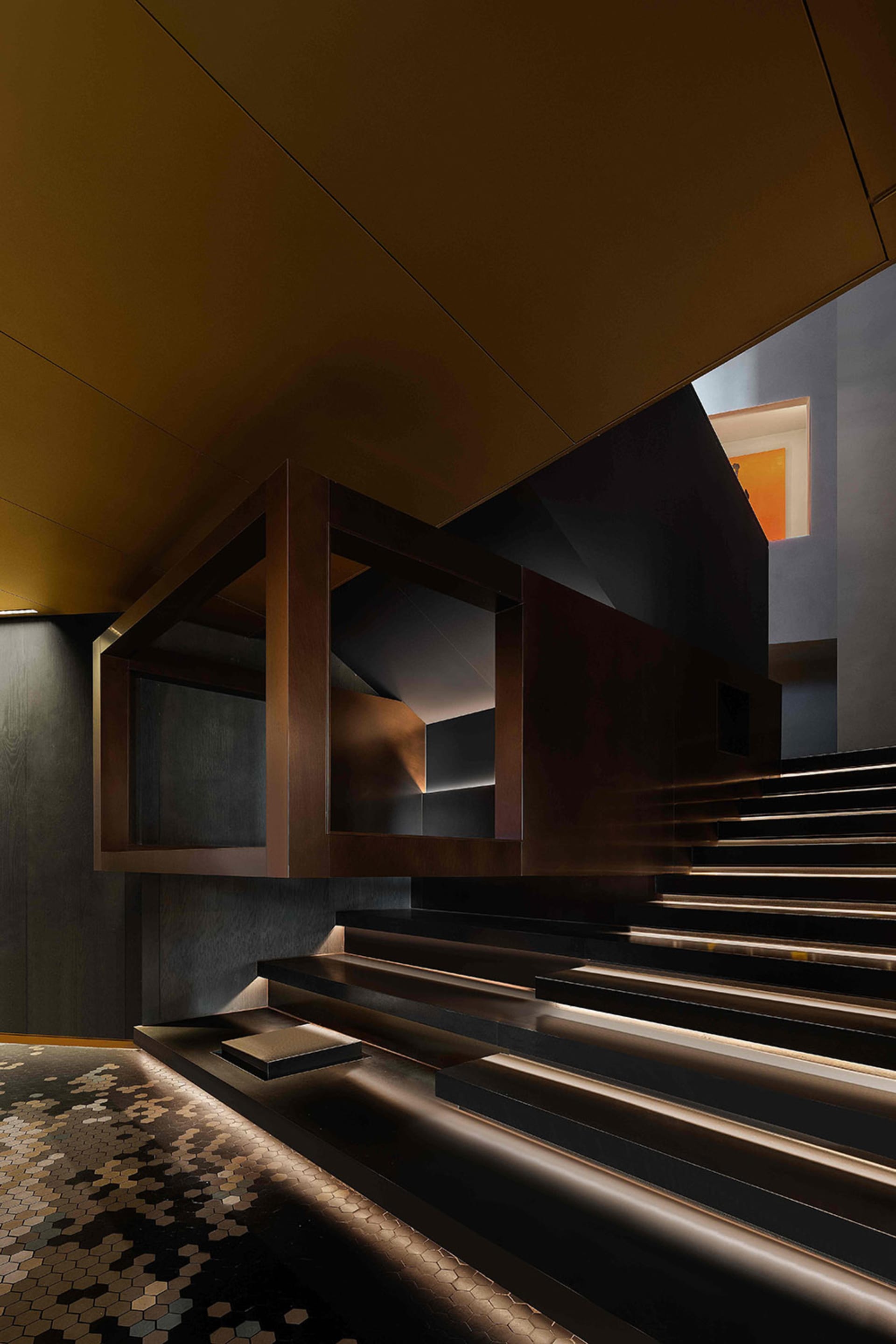 A cozy living space with a staircase made of wood and a black railing, with two sets of stairs on either side