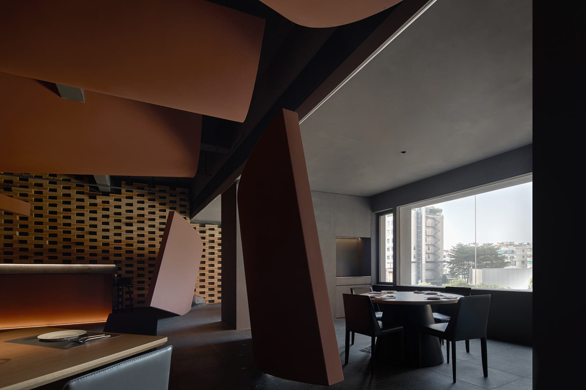 Modern restaurant interior with red and brown walls, natural light, and seating areas