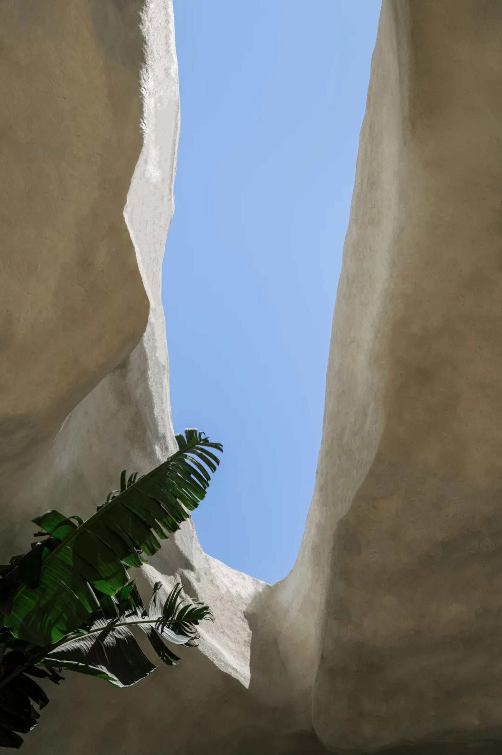 A large rock formation with a central cave or tunnel, surrounded by rocks and possibly vegetation, creating a unique atmosphere