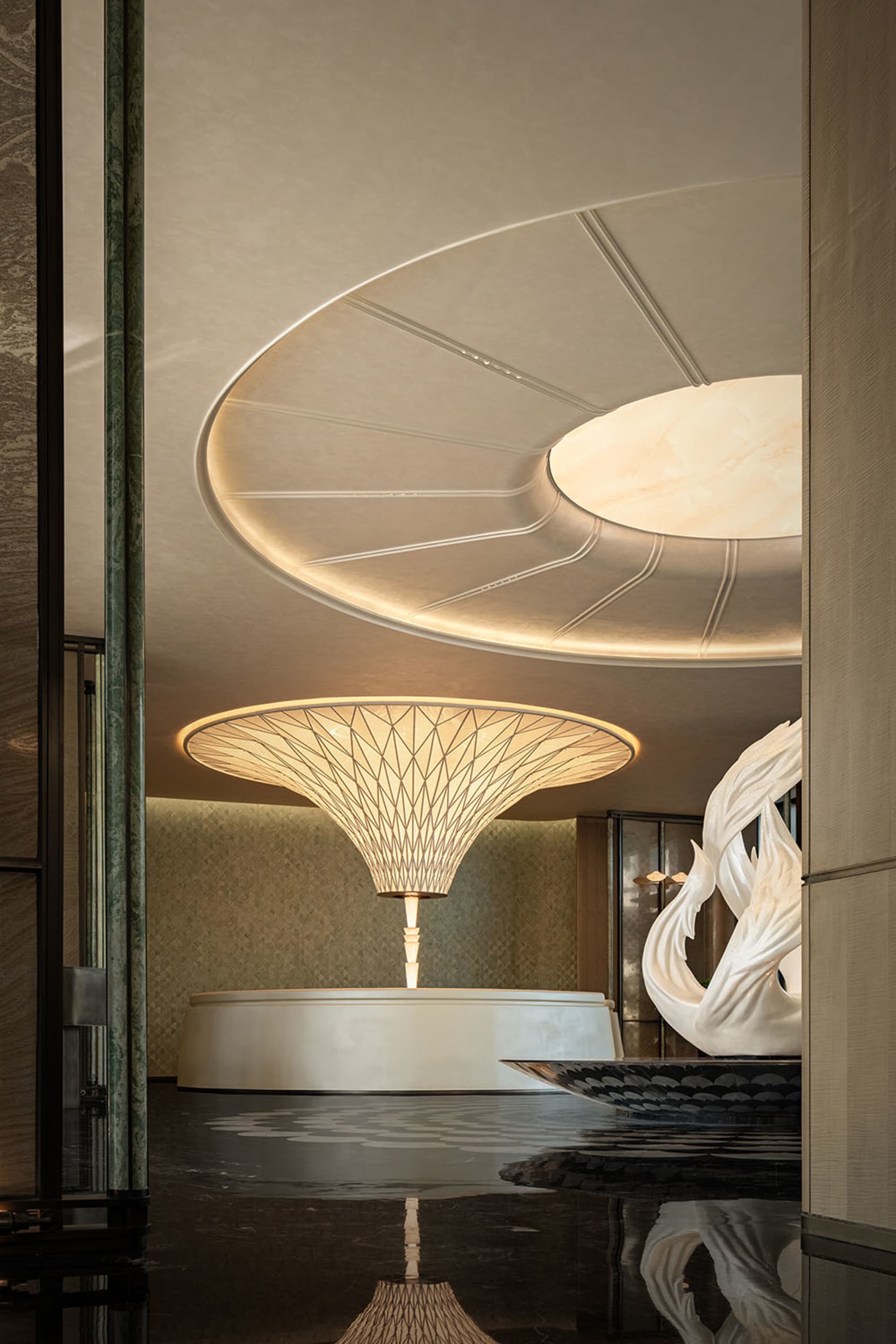 A modern room with a circular sculpture, white and beige walls, and a calm atmosphere, ideal for relaxation or social gatherings