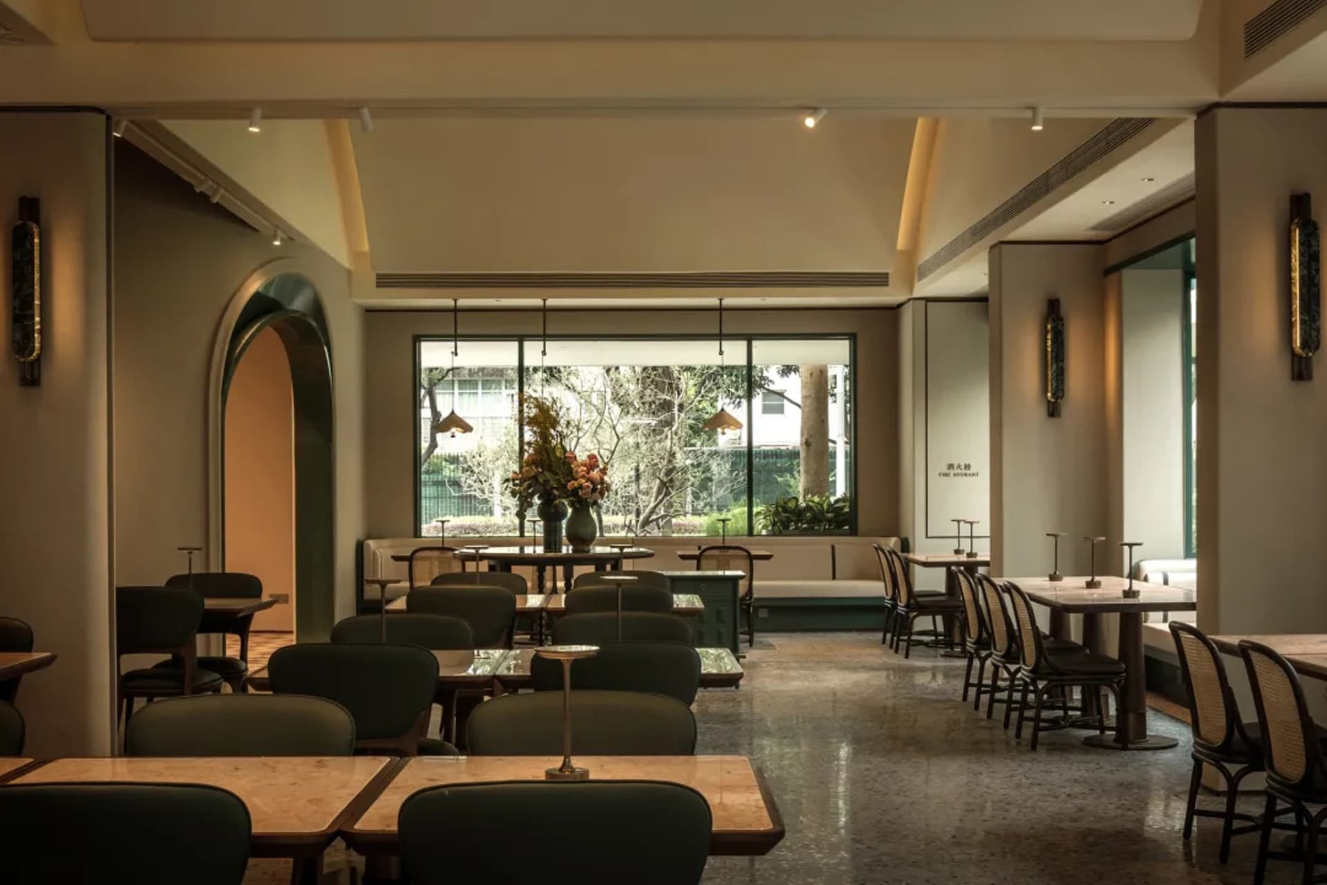Modern restaurant interior with tables, chairs, potted plants, and inviting ambiance