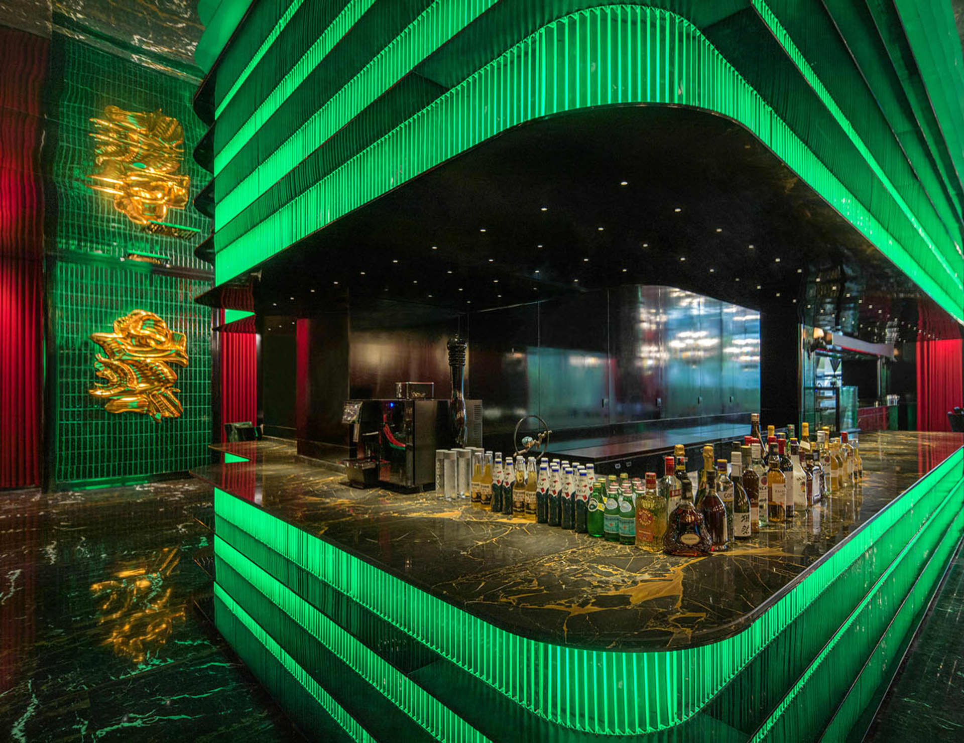 A well-stocked bar area with a large number of bottles displayed on a countertop, creating an inviting atmosphere for patrons