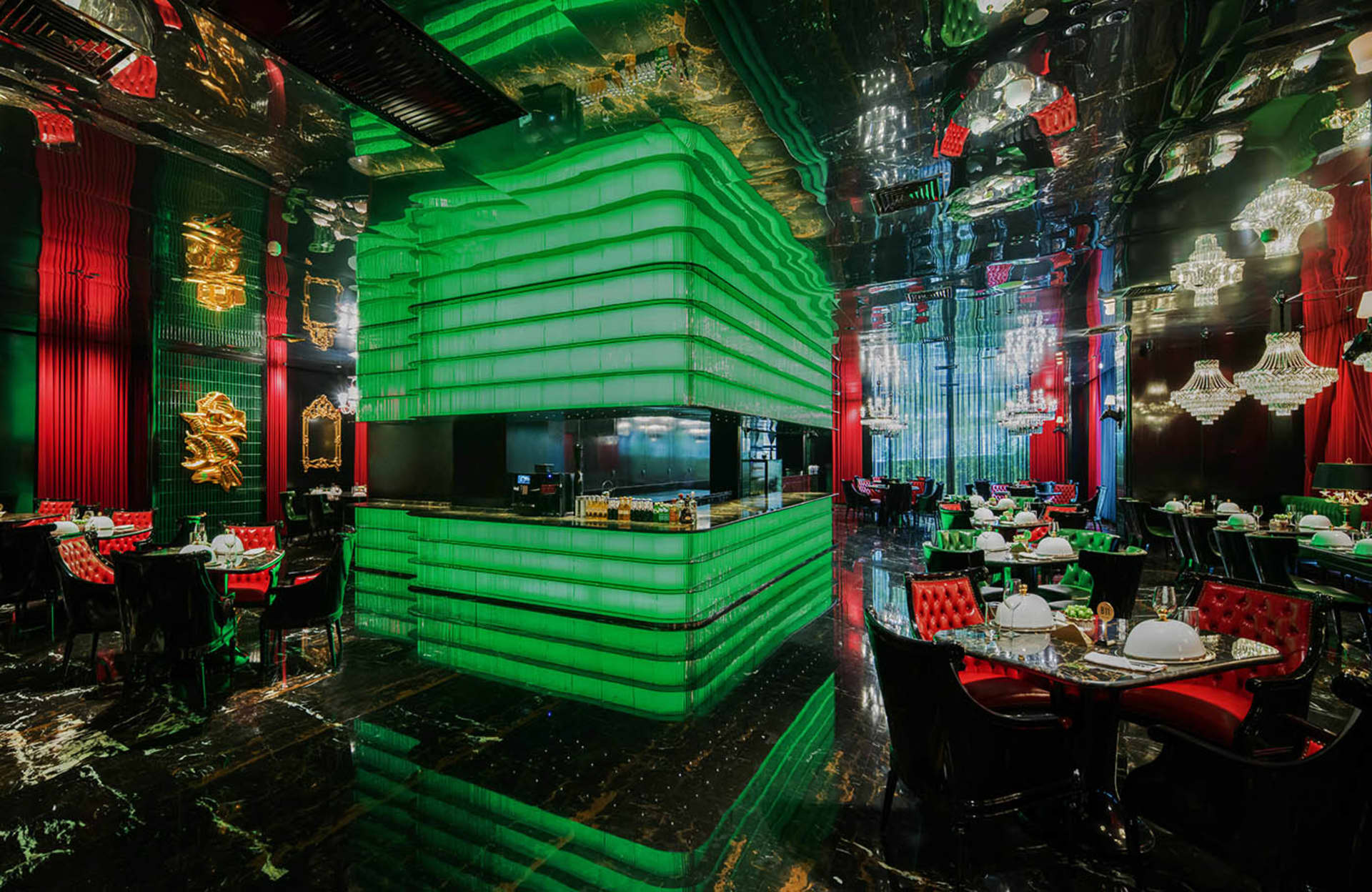 A modern restaurant with green walls and flooring, featuring a warm and inviting atmosphere created by the lighting