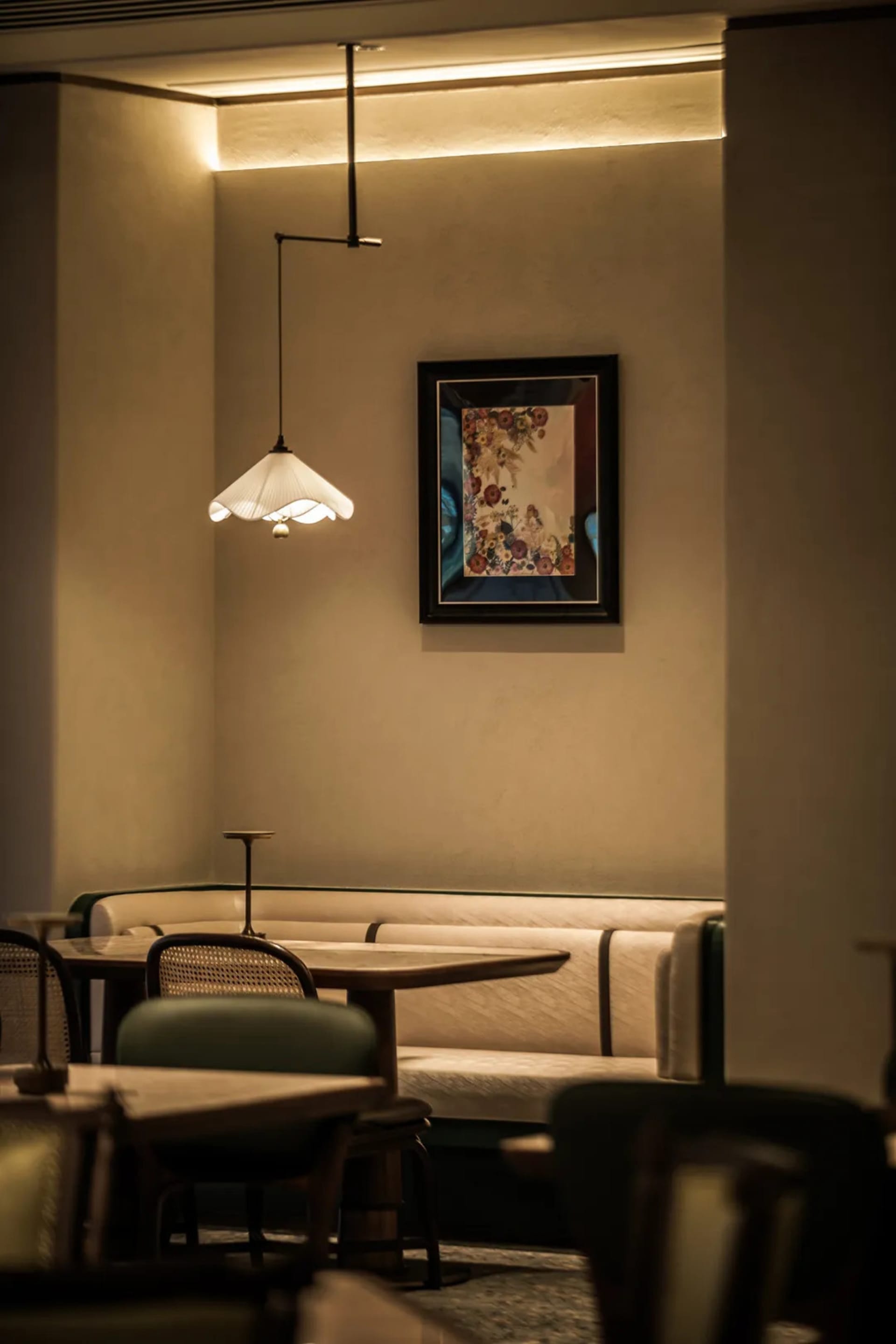 Dining area with wooden tables and chairs, a vase on one table, and an inviting atmosphere
