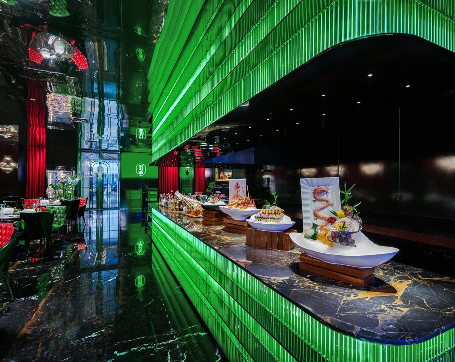 A modern restaurant dining area with multiple tables, green accents, potted plants, and bowls of food on the tables