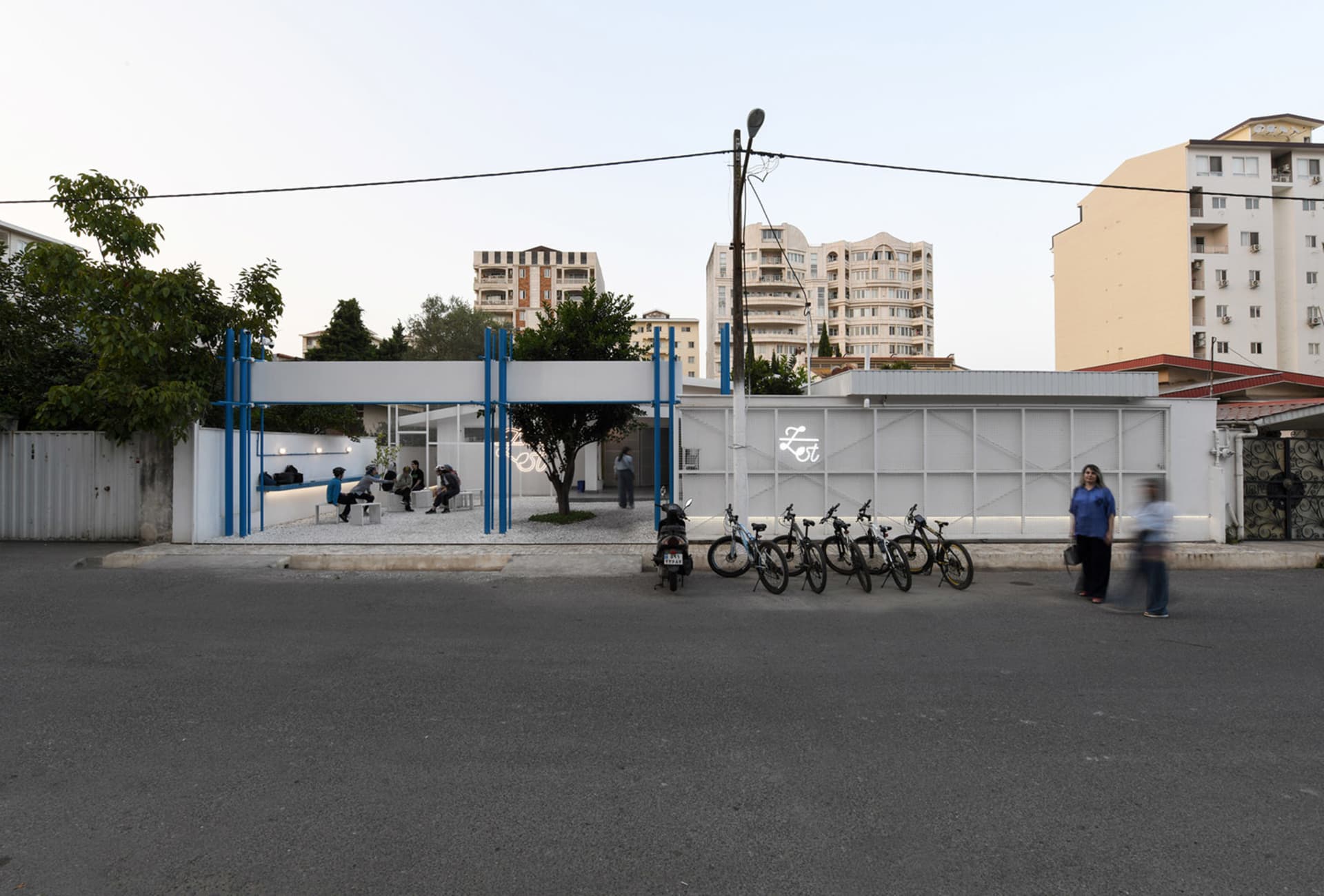 A bustling urban street scene with bicycles parked on the sidewalk and pedestrians going about their daily activities