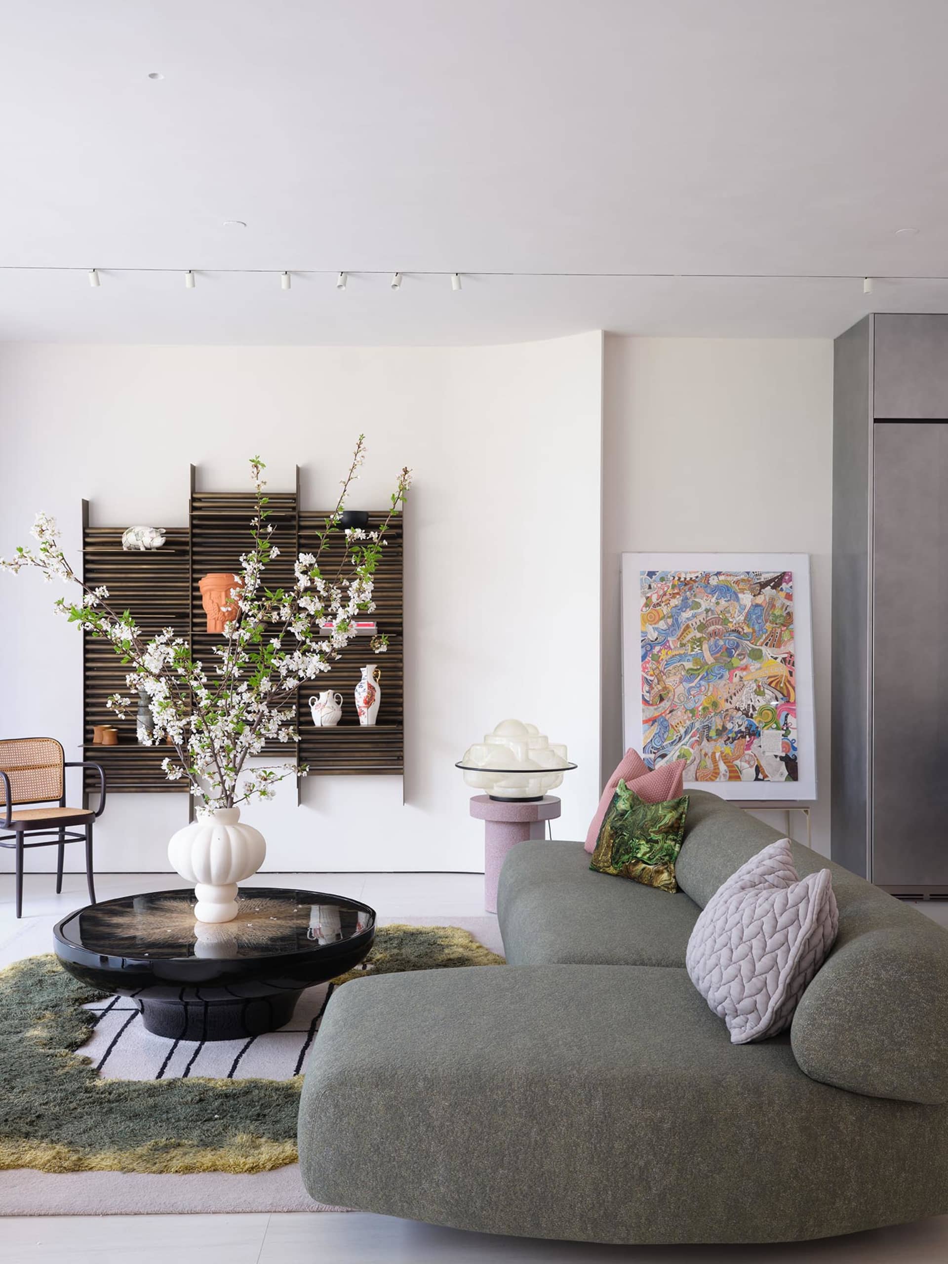 Cozy open living area with a couch, chair, dining table, potted plants, and decorative vases