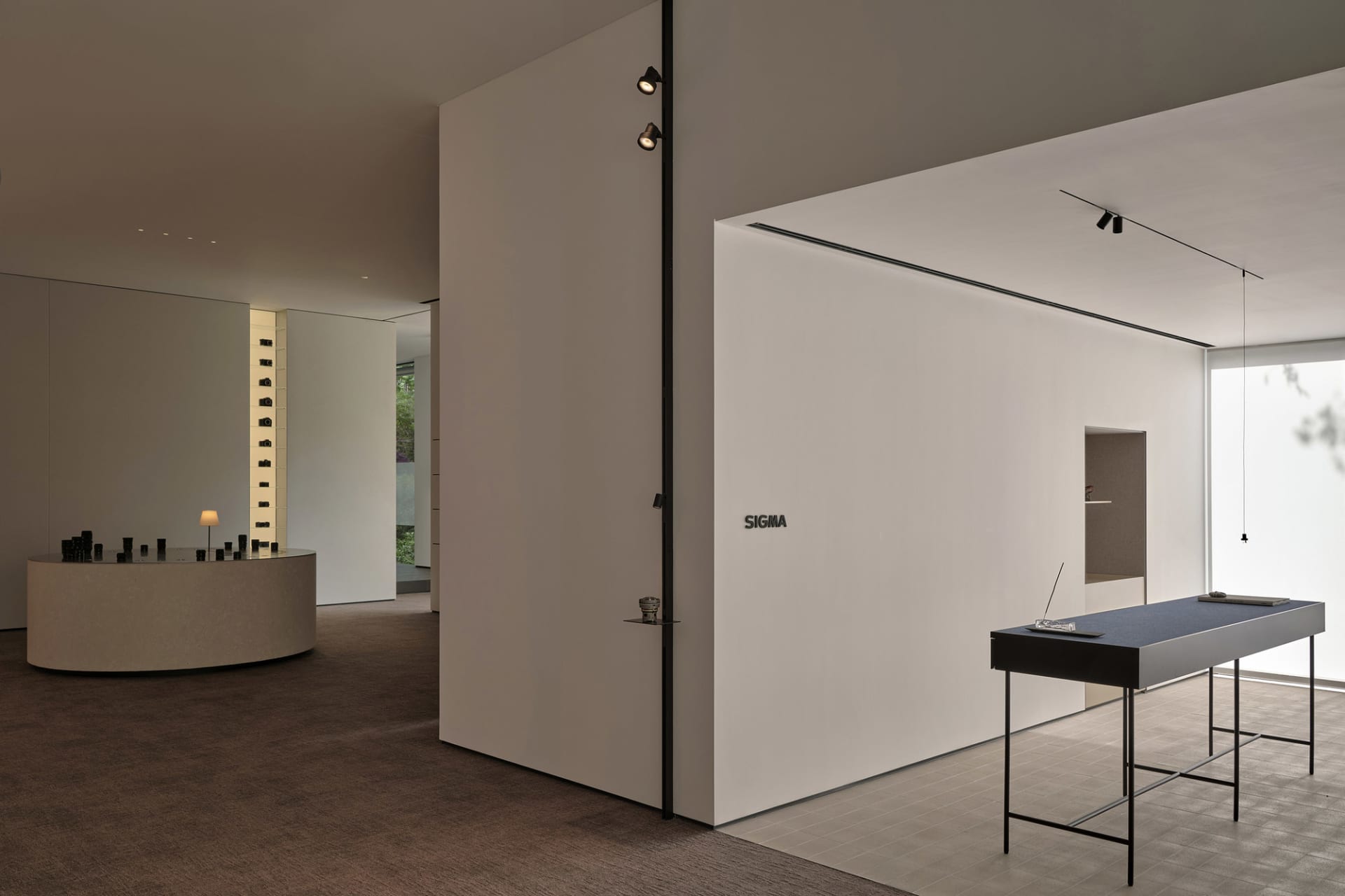 Empty office space with white walls, a black table, and a laptop, creating a calm and organized atmosphere