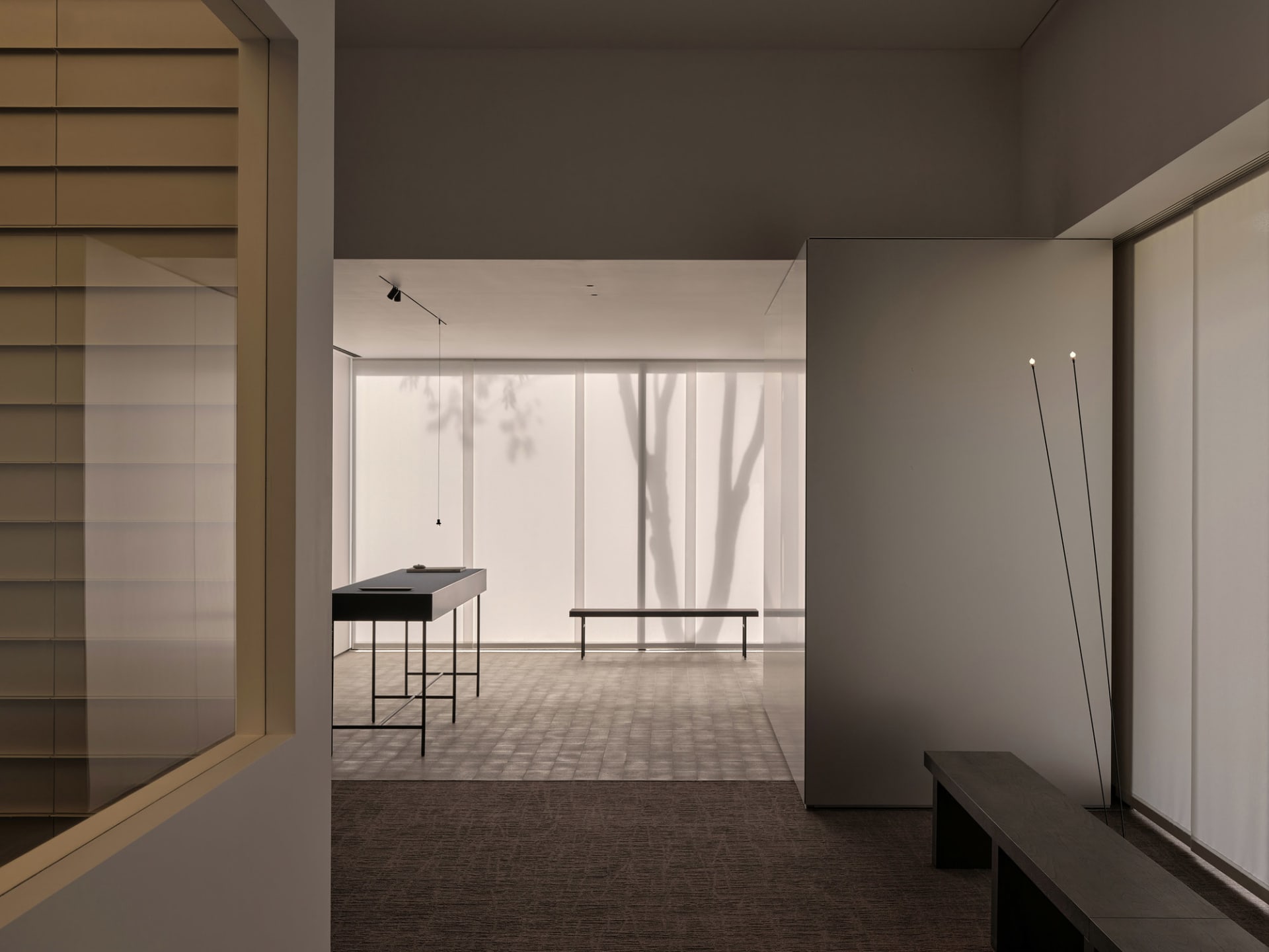 A calm and inviting lobby with two benches, a large window, and natural light