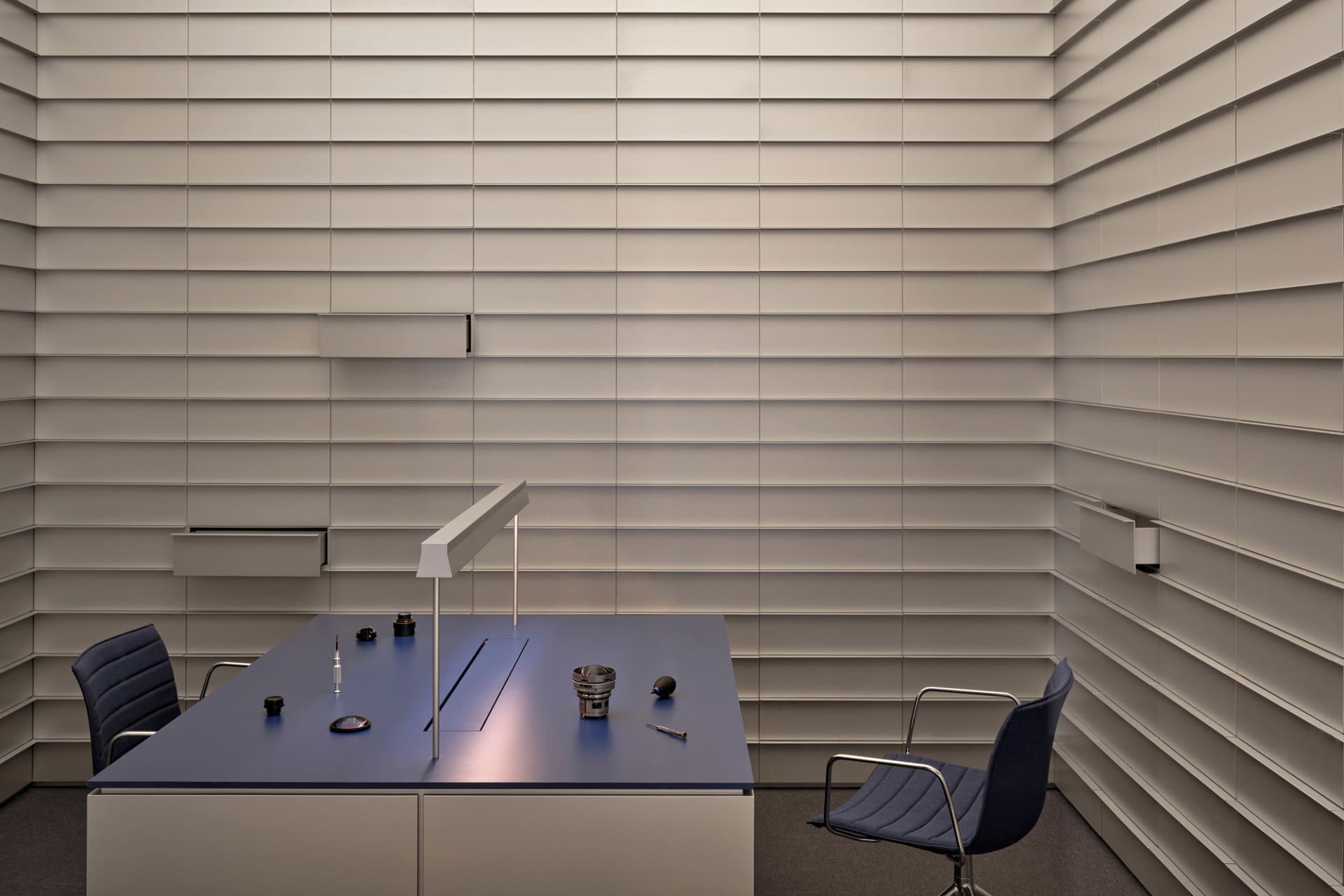 A professional office space with a wooden desk, chair, and various office items, set against a neutral background