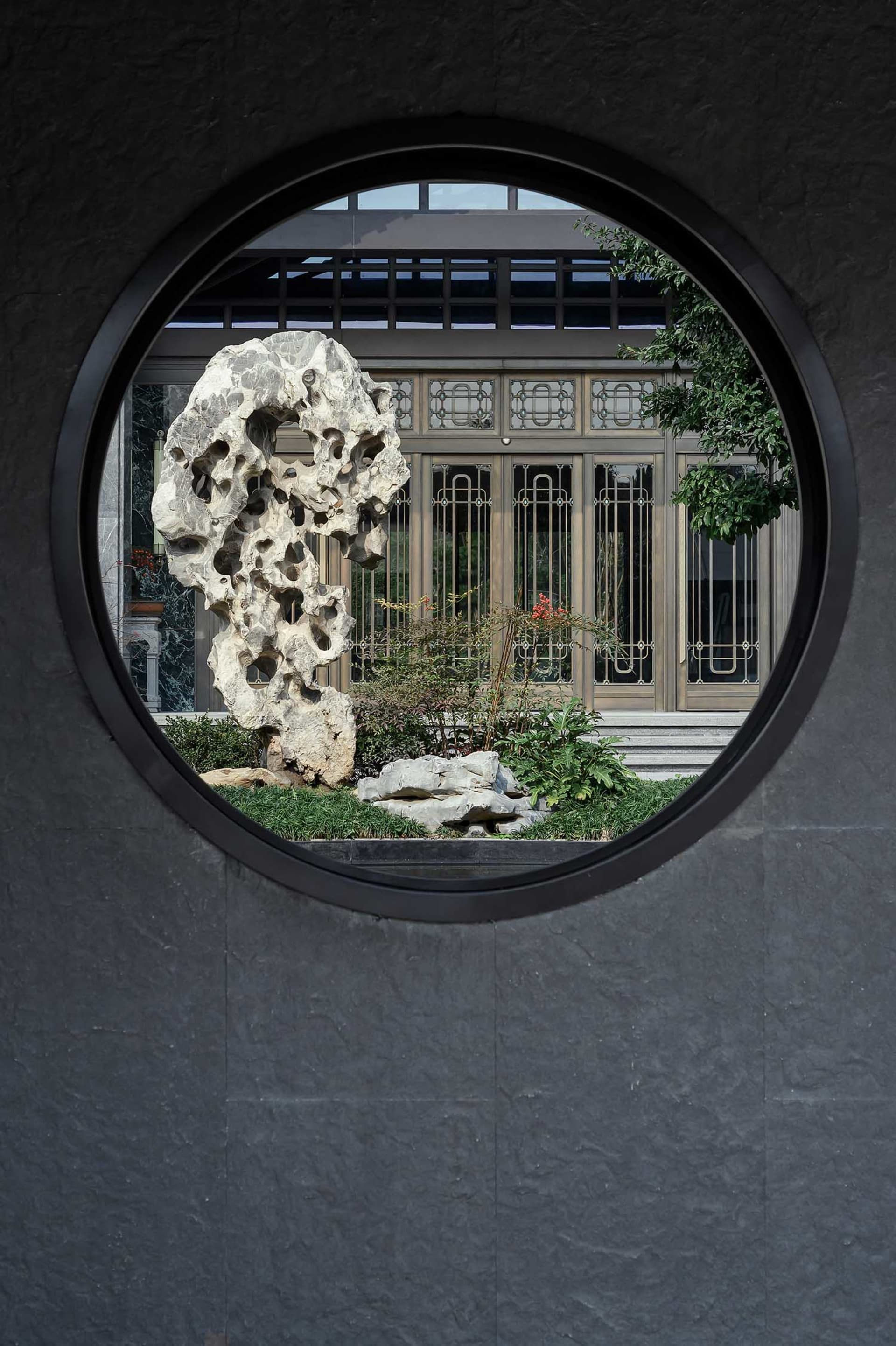 亞洲風格建築室內，擁有大型圓形窗戶與盆栽植物增添氛圍，營造獨特而溫馨的環境