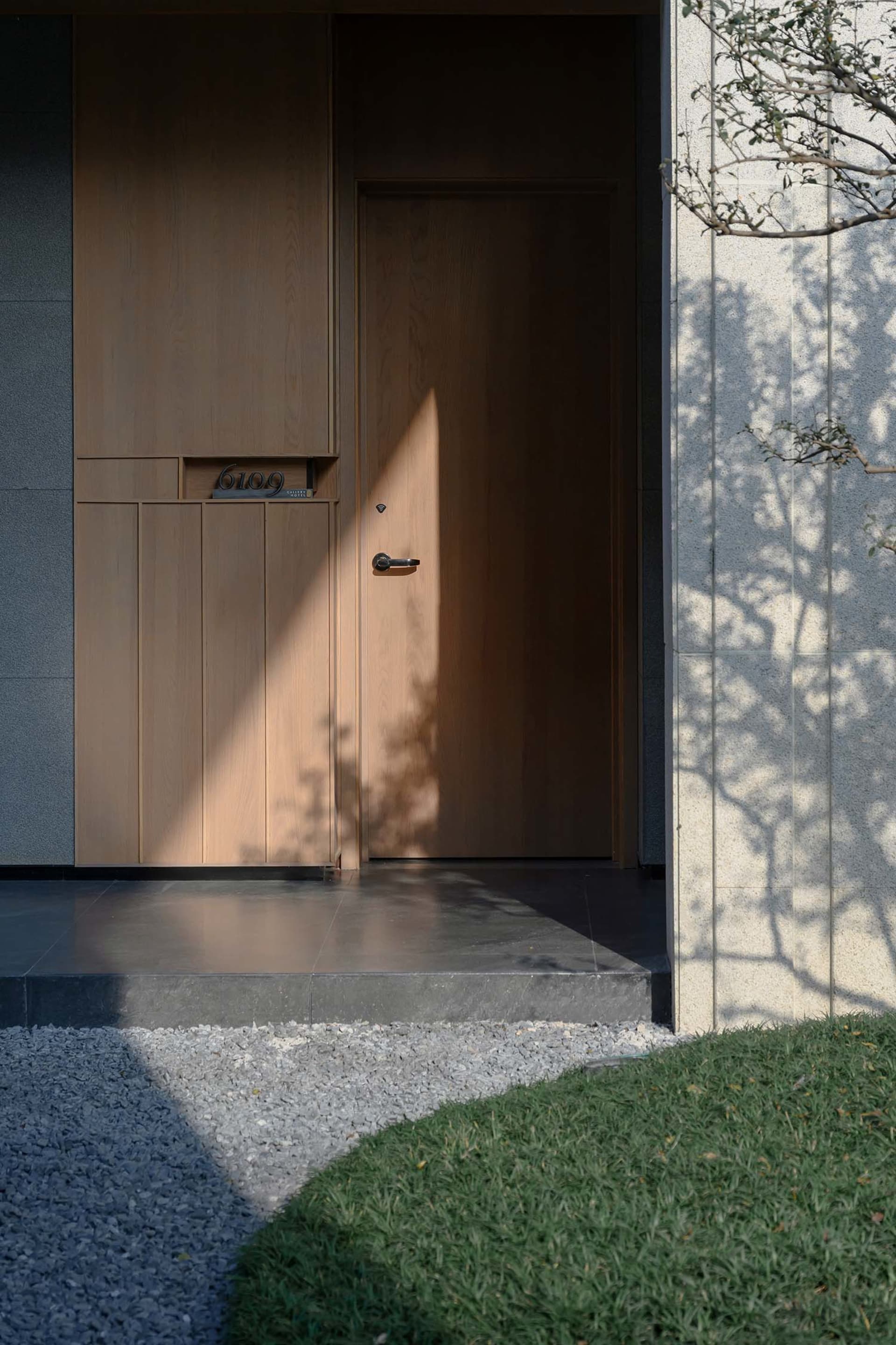 A traditional entrance with a wooden door featuring a glass window, creating a welcoming atmosphere