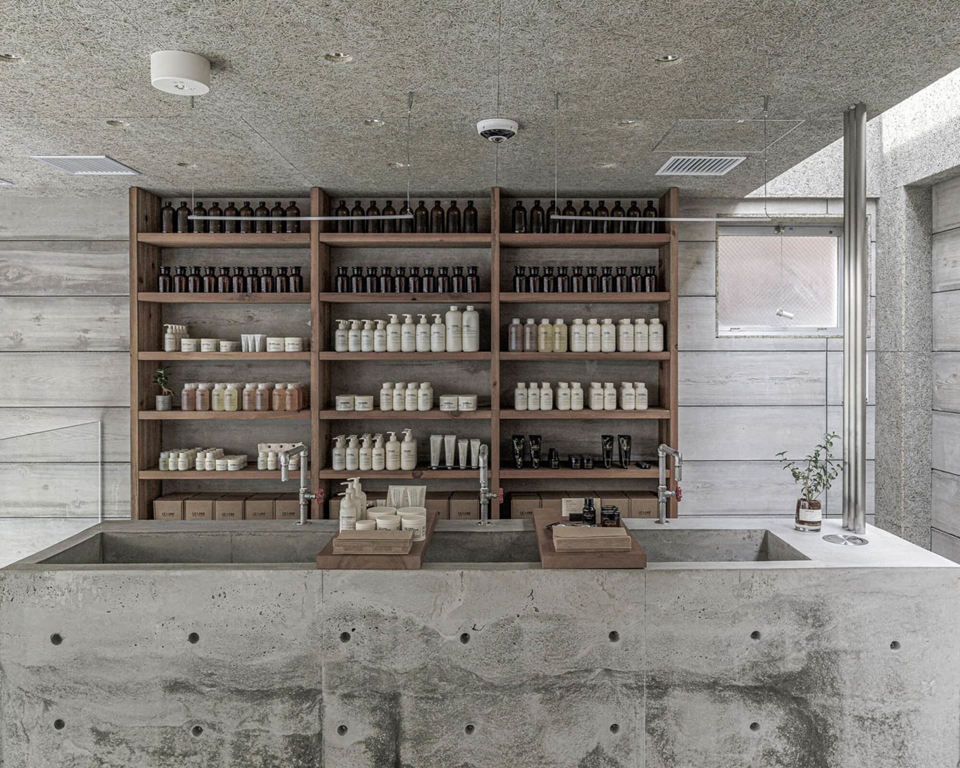 Bathroom with a sink and multiple shelves displaying various bottles of soap, creating a clean and organized atmosphere