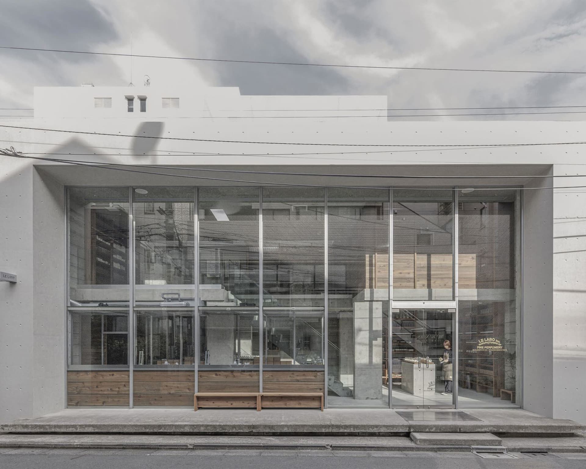 A modern building with large glass walls and natural light, featuring outdoor seating areas and a contemporary atmosphere