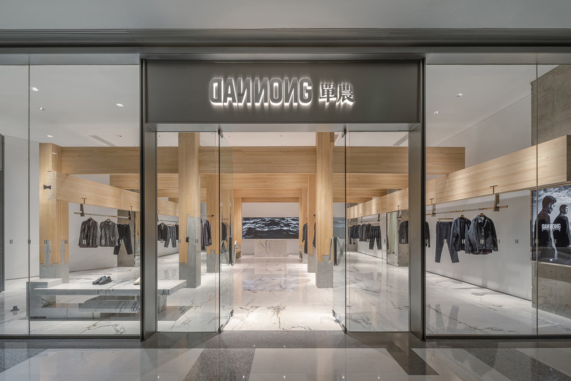 Spacious modern retail space with glass doors, natural light, and mannequins displaying clothing items