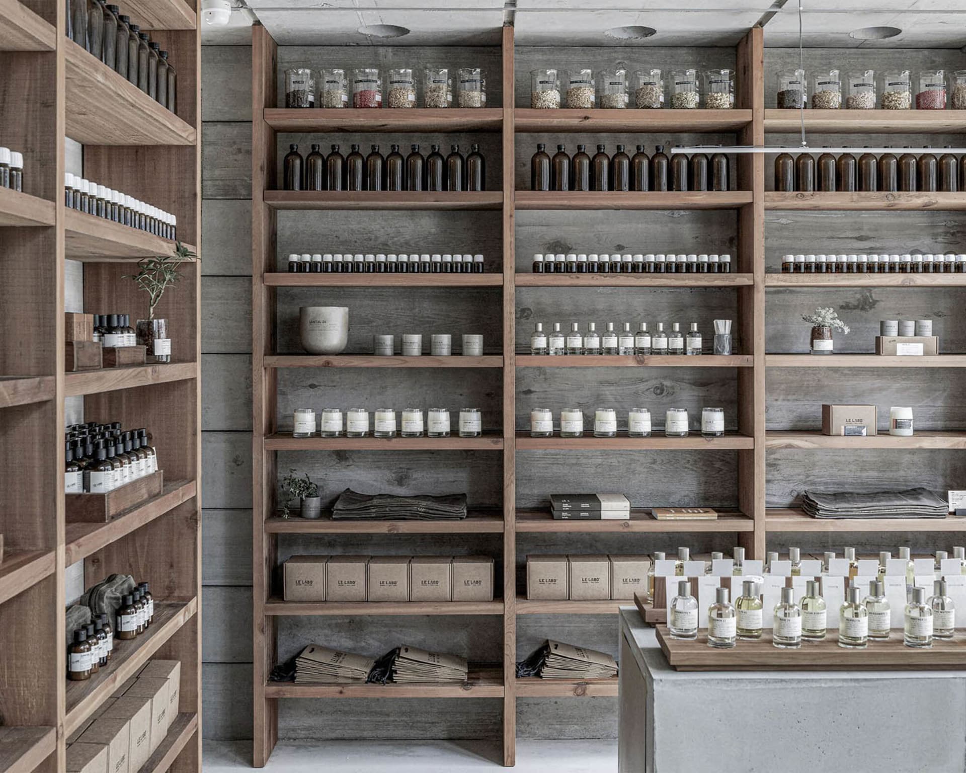 Dimly lit store with wooden shelves and stone walls, displaying bottles, vases, and bowls, with a cozy atmosphere