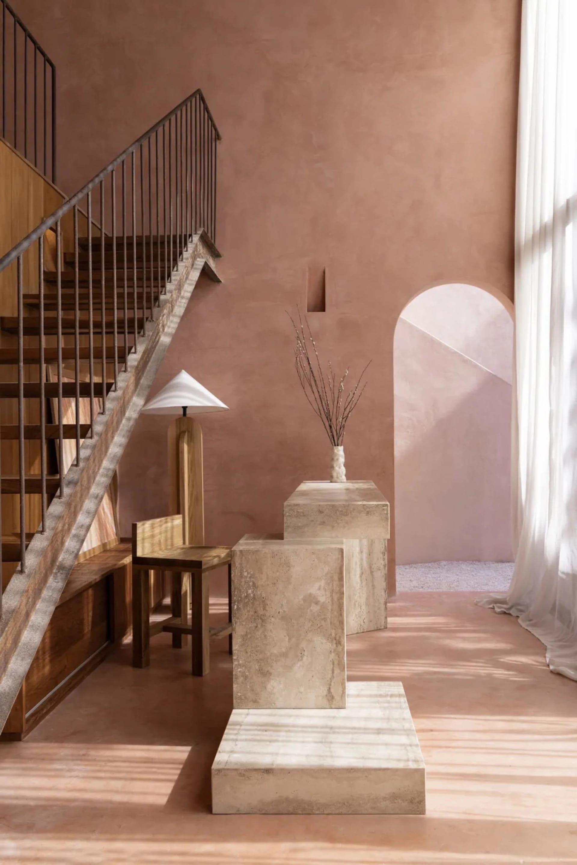 Cozy interior stairwell with a wooden railing, two chairs, and a vase, creating a welcoming atmosphere