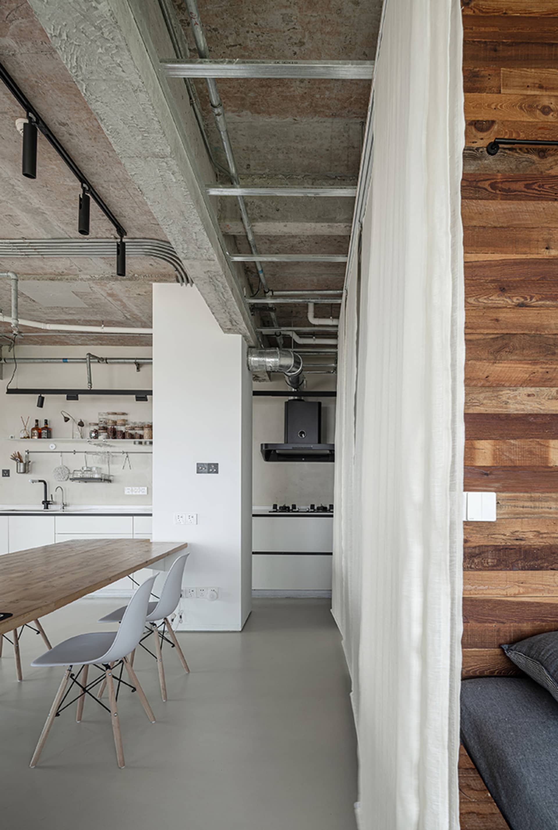 A modern kitchen and dining space with a large white table and chairs, sink, and oven, creating a functional and comfortable living area