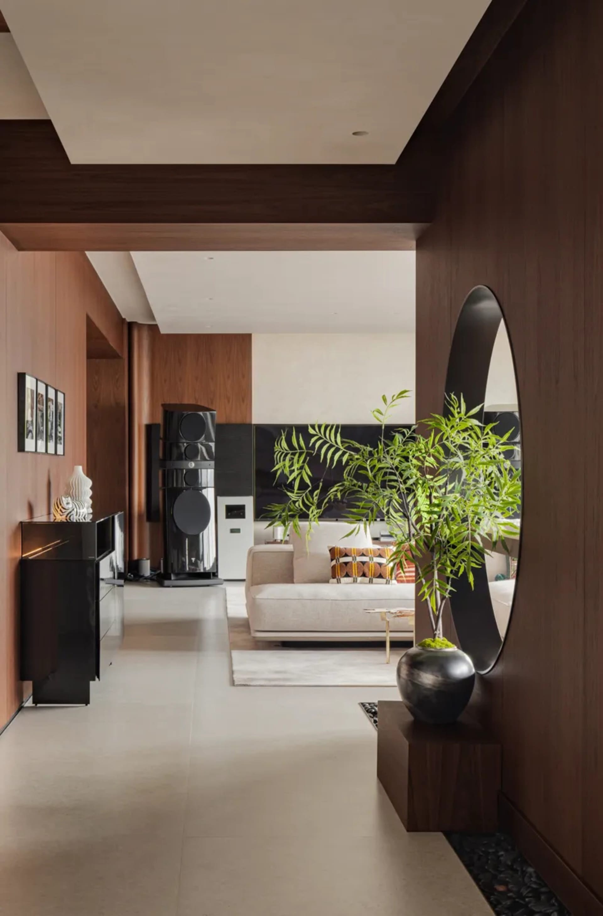 Open concept living and dining area with modern furniture, a TV, and a potted plant, surrounded by well-lit walls and a dining table with chairs