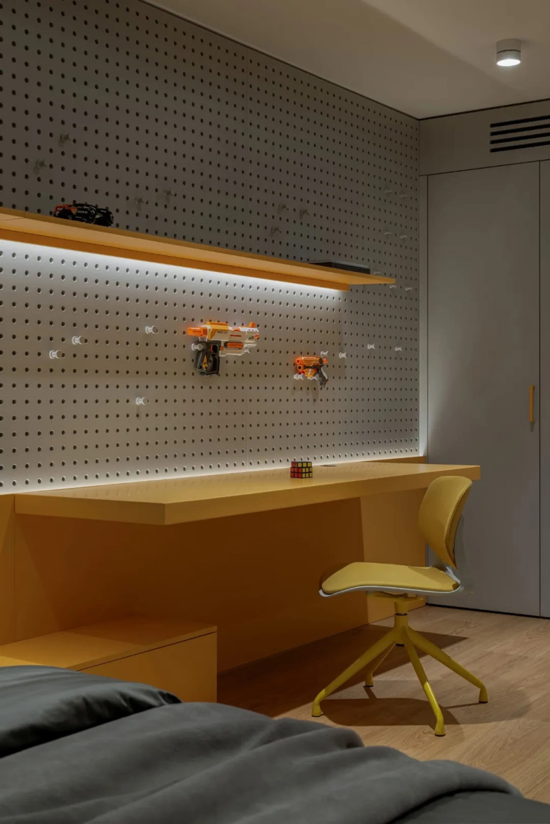 A well-lit room with a yellow desk, two chairs, and a playful atmosphere