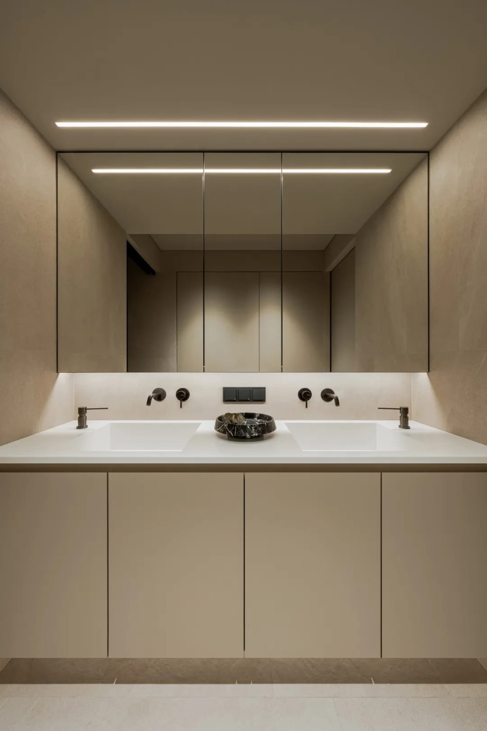 A modern bathroom with a white sink, two faucets, and a clean, well-lit atmosphere