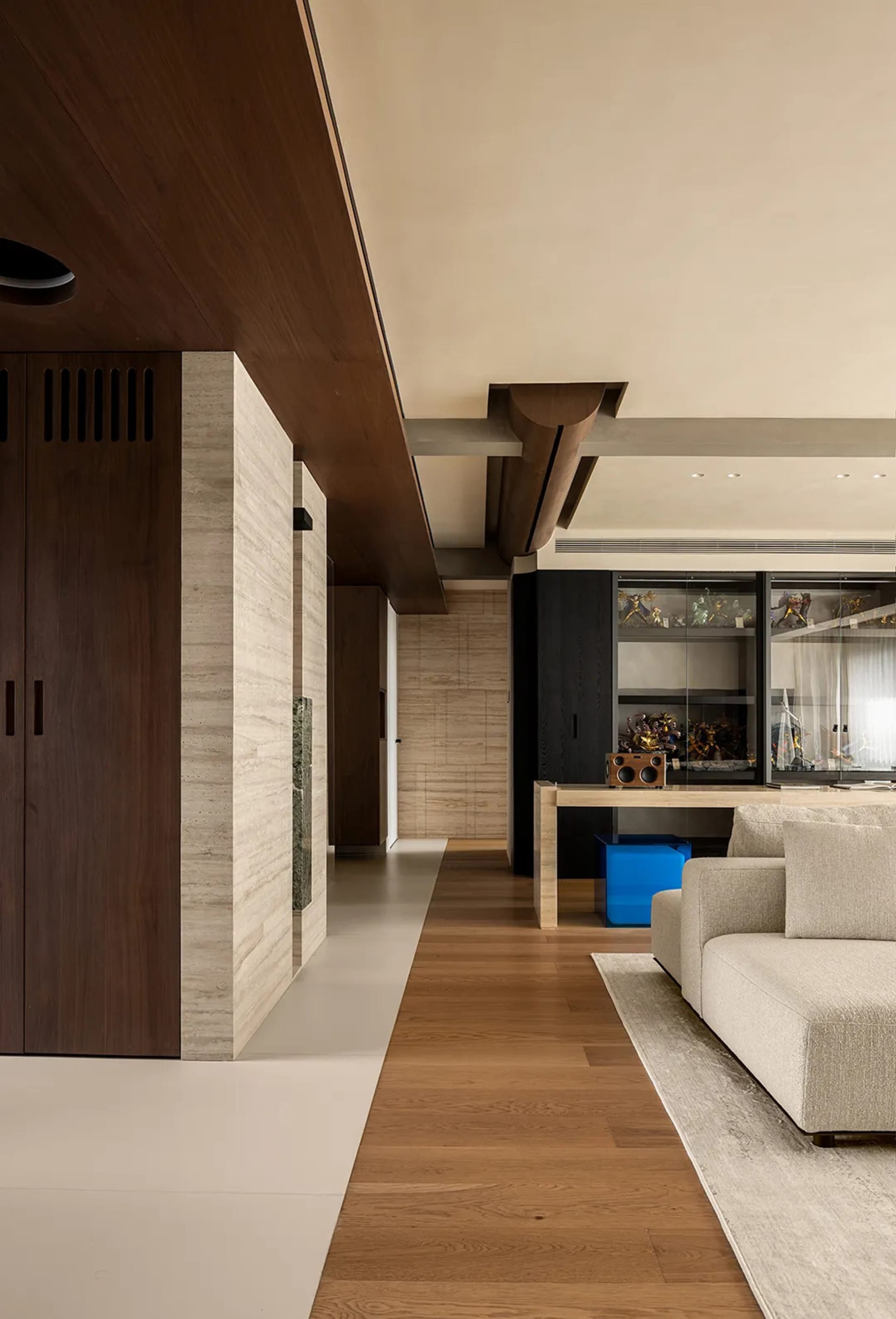 Open living space with hardwood flooring, a large couch, two chairs, and natural light from windows on both sides